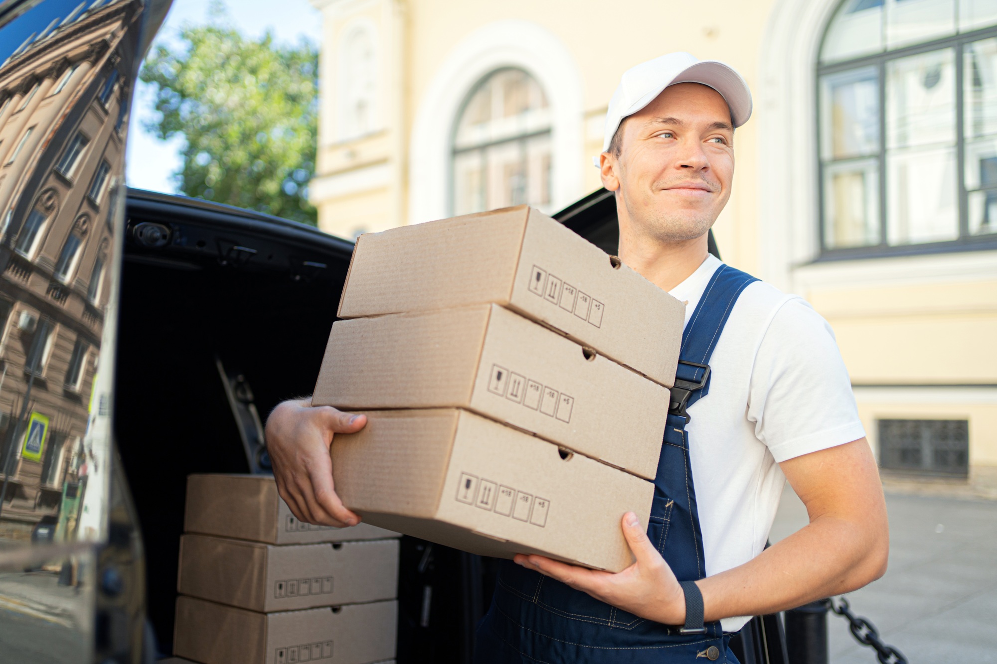 Friendly delivery man carrying boxes, efficient service.