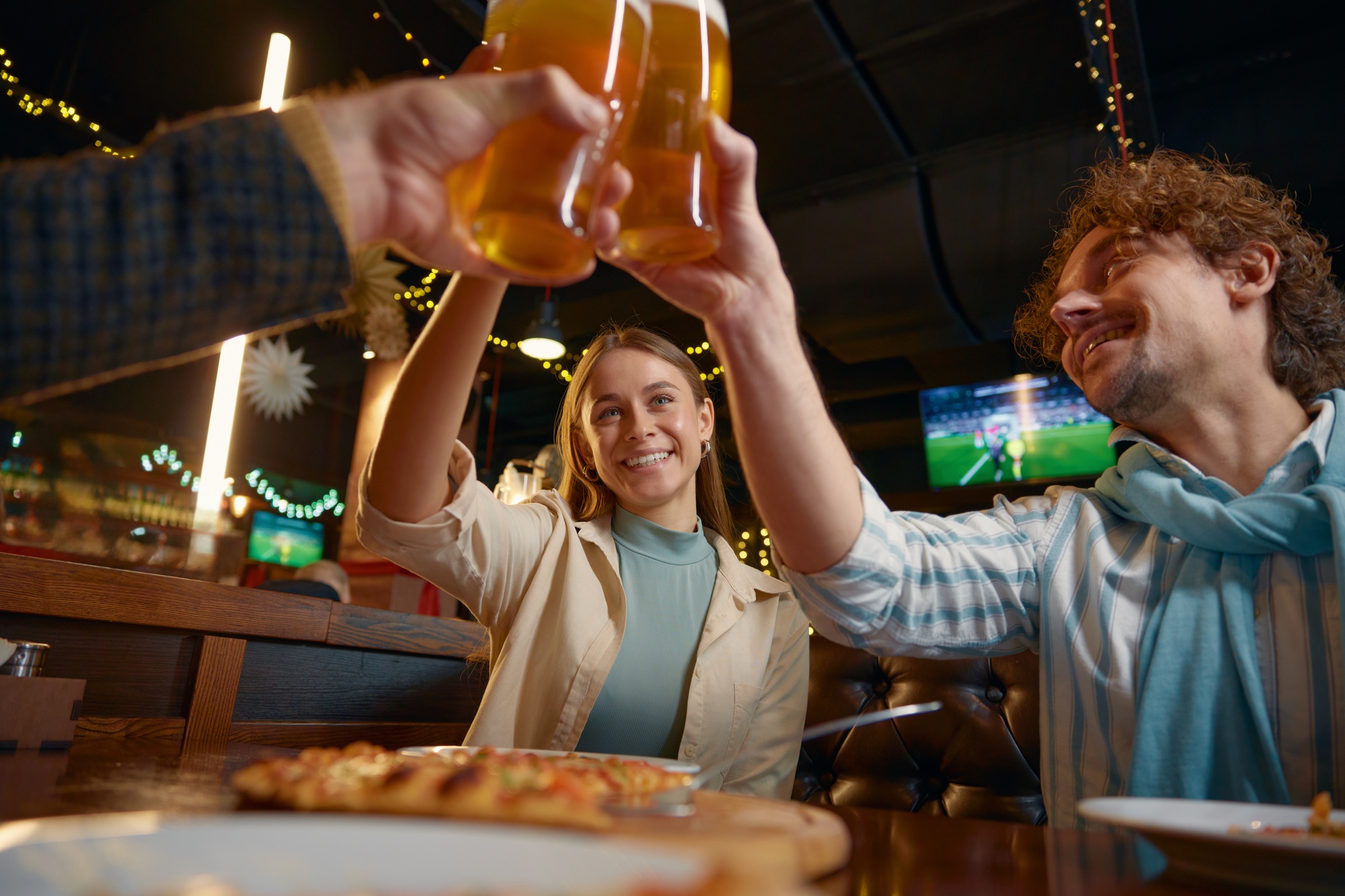Friends drinking beer celebrating end of work week resting in pub