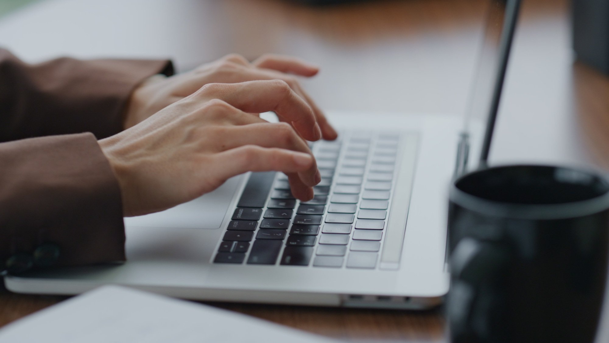 Girl secretary typing business letter on modern laptop sitting office close up