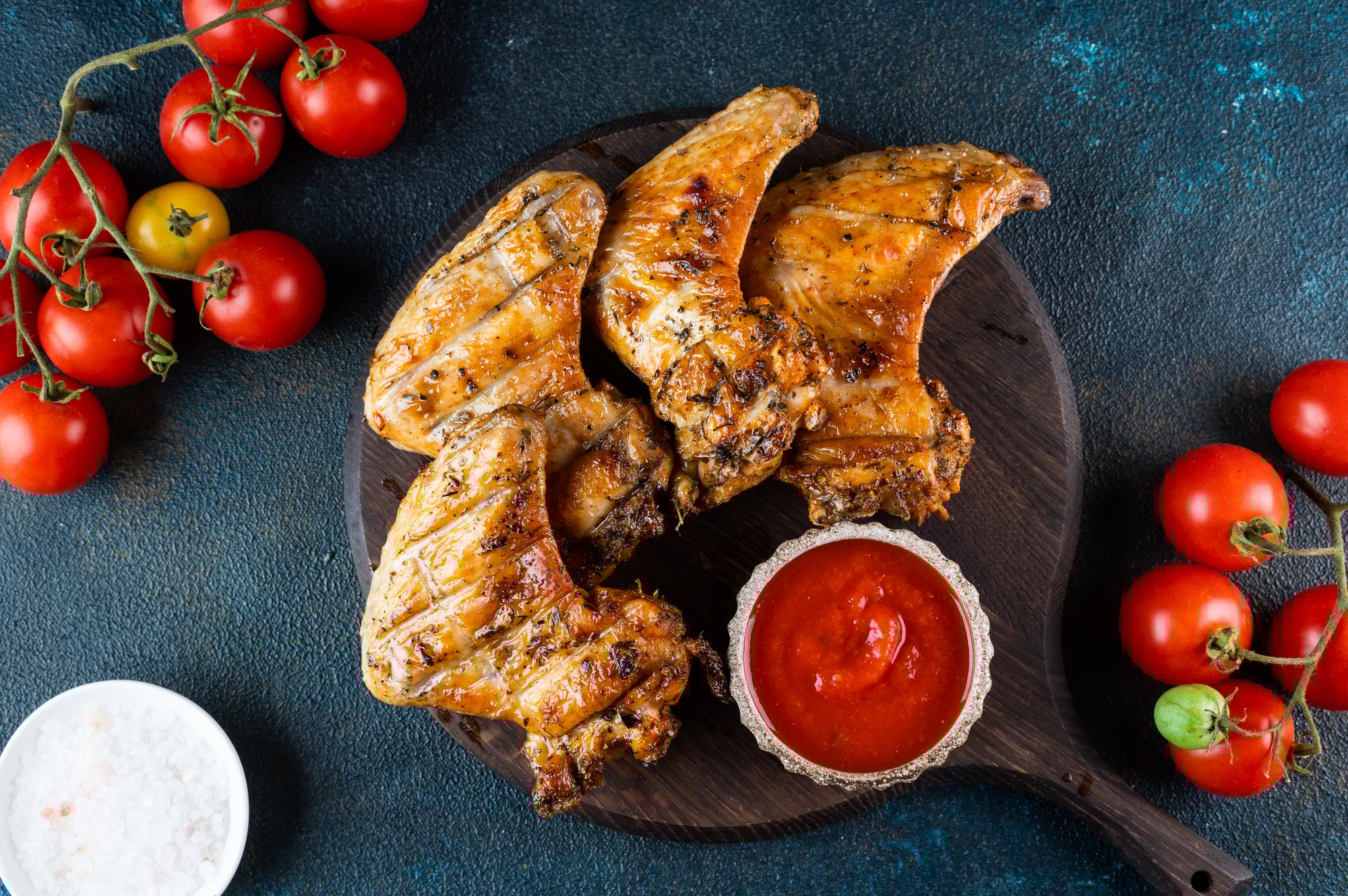 Grilled spicy chicken wings with ketchup . Top view with copy space. BBQ concept.