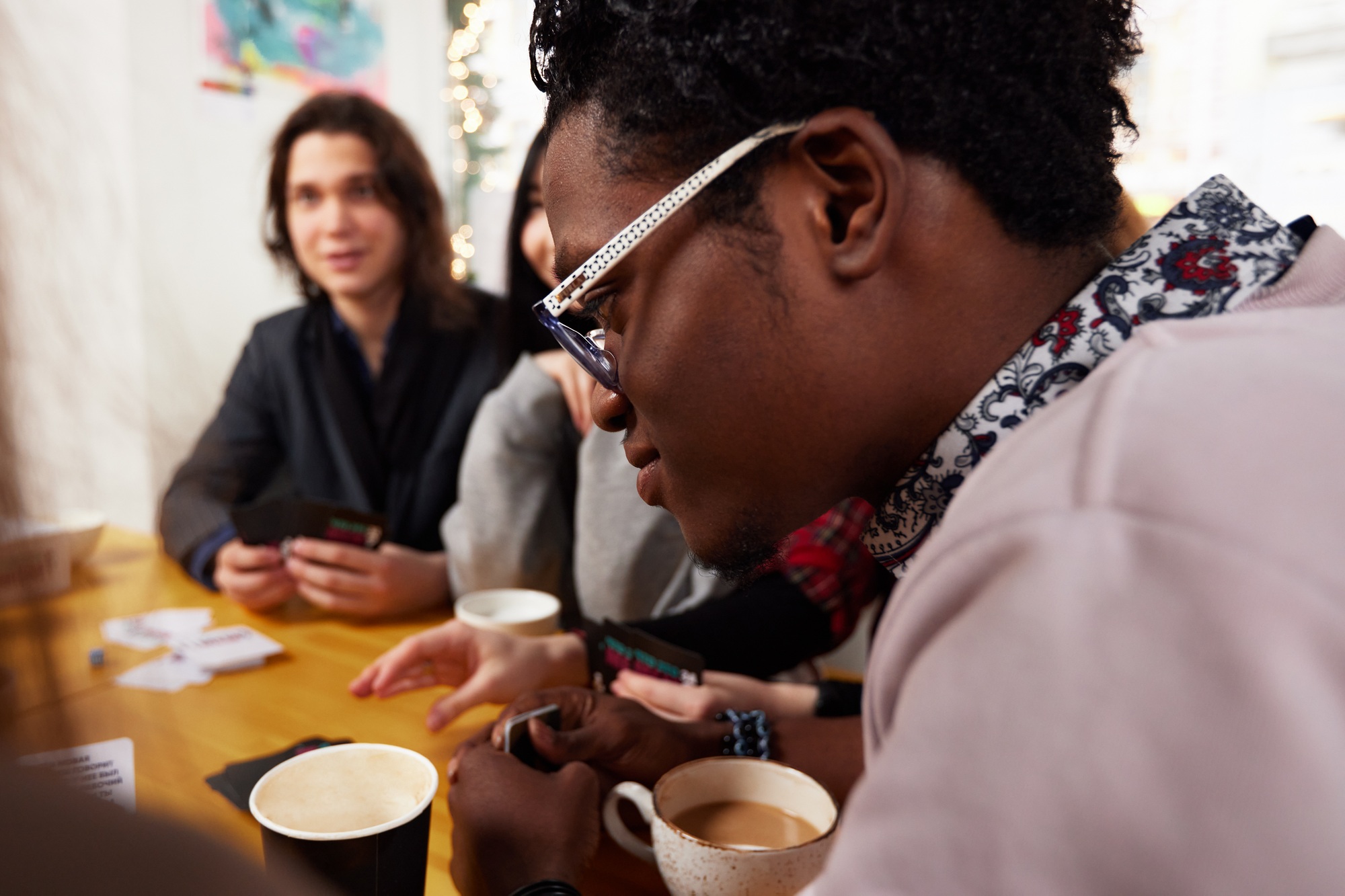 Group of multiracial young people sharing ideas and having friendly conversation during coffee break