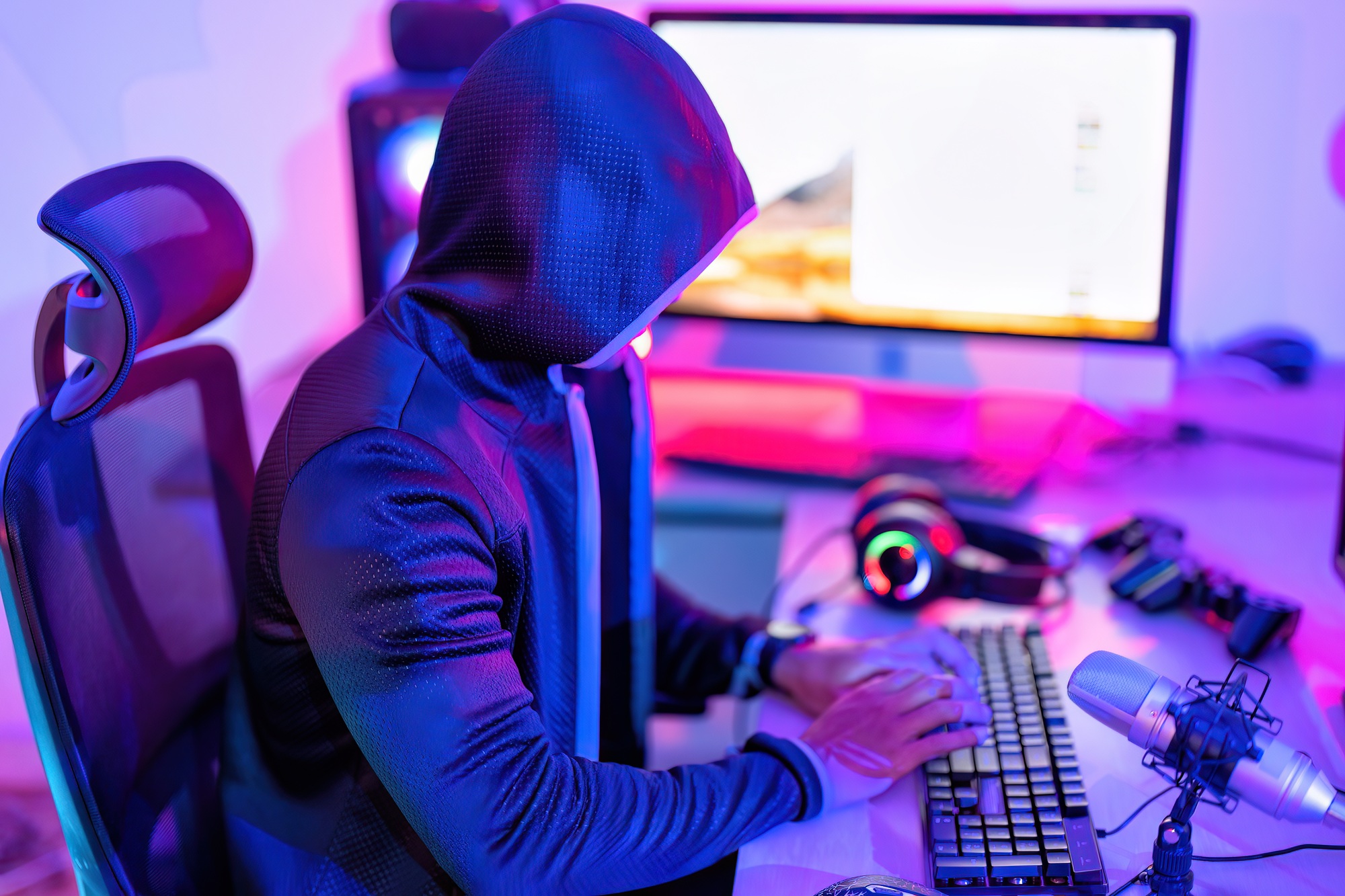 hacker wearing hood jacket typing computer keyboard to phishing steal attack