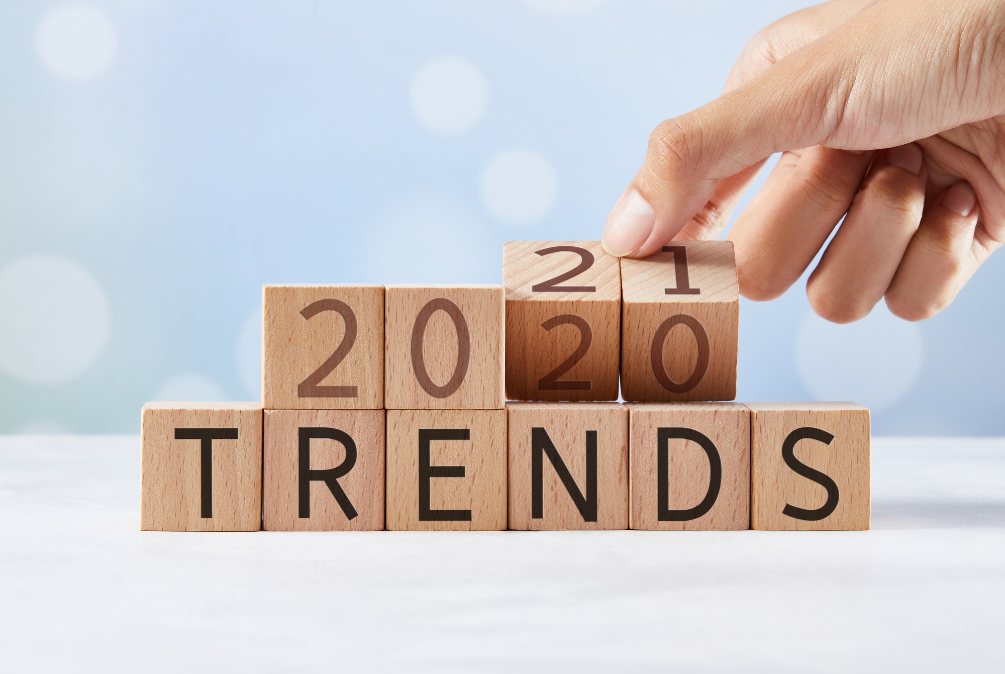 Hand flipping wooden blocks and changing the expression "trends 2020" to "trends 2021"