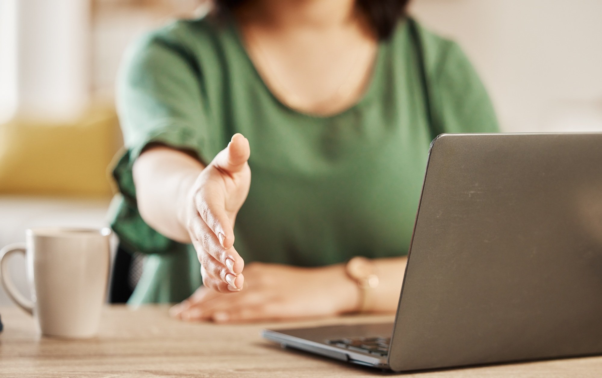 Handshake, remote work and hand with laptop, greeting and welcome in a home. House, computer and sh