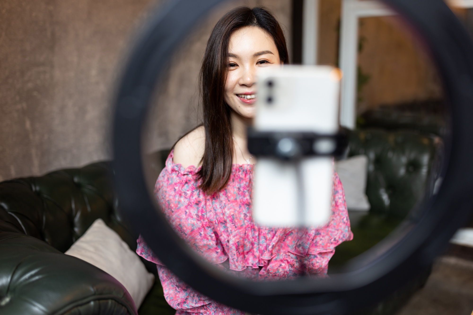 Happy asian woman influencer using technology in cafeteria or studio
