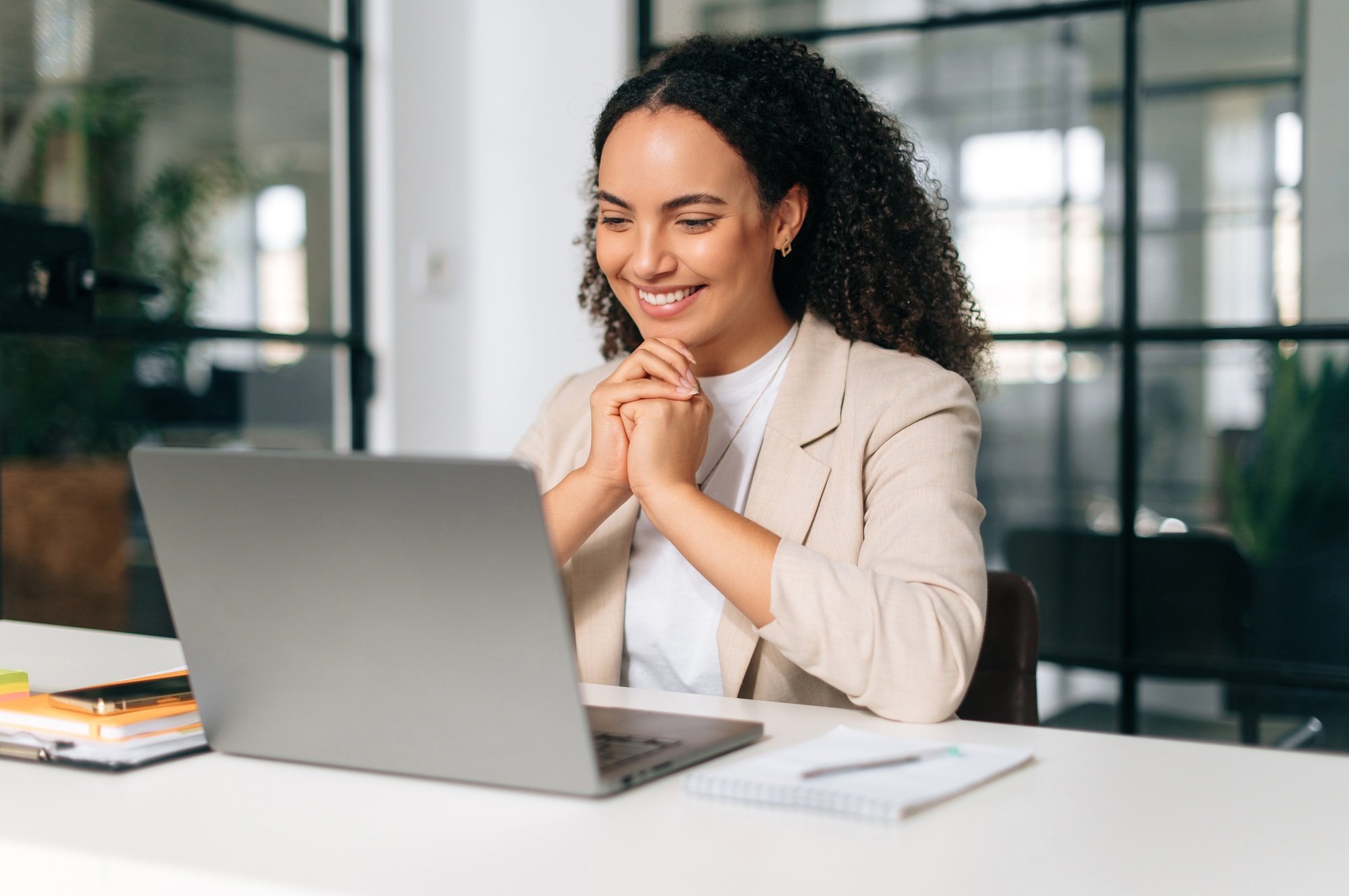 Happy brazilian or hispanic curly haired business woman, company ceo, recruitment manager, sitting