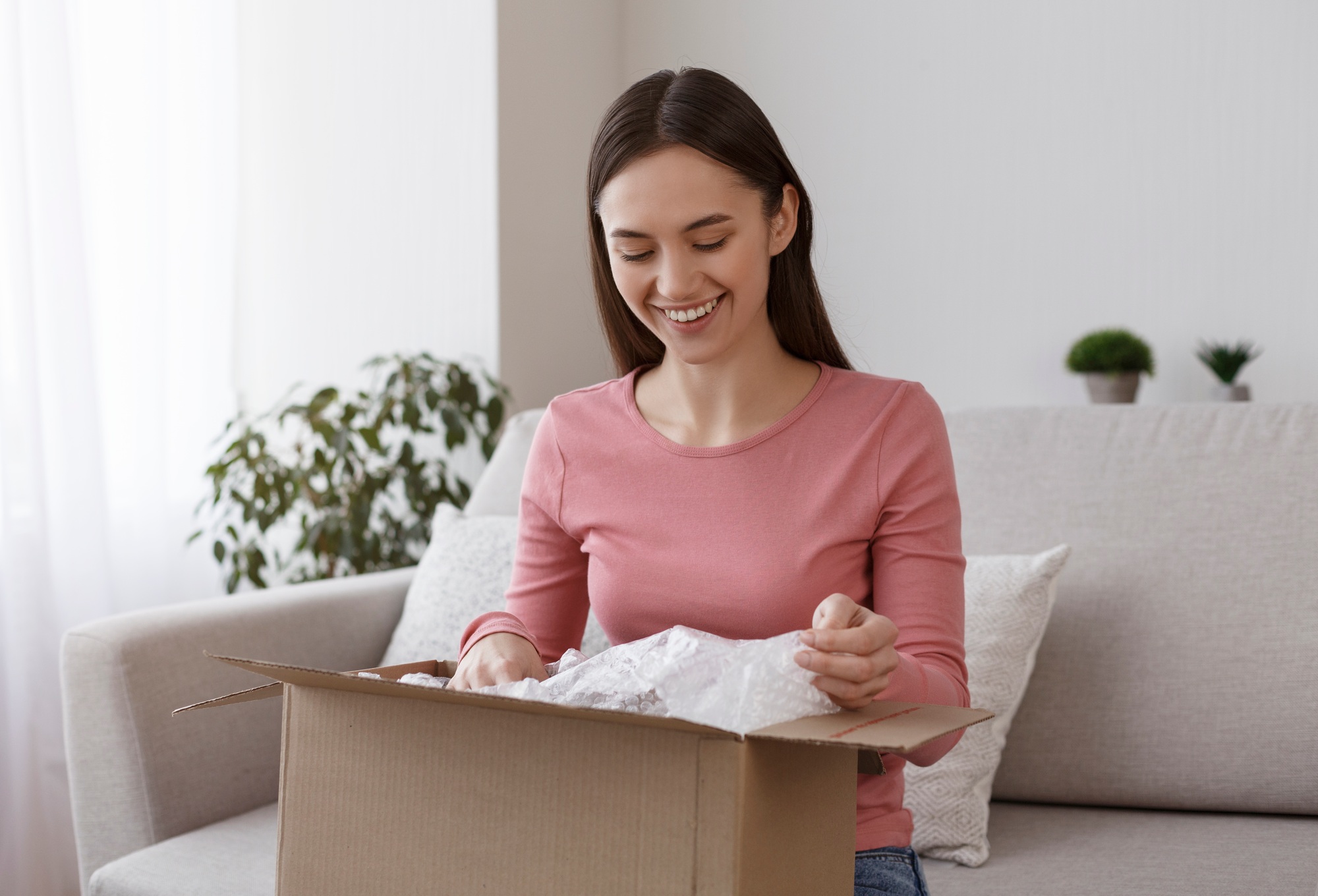 Happy young girl unboxing international package at home