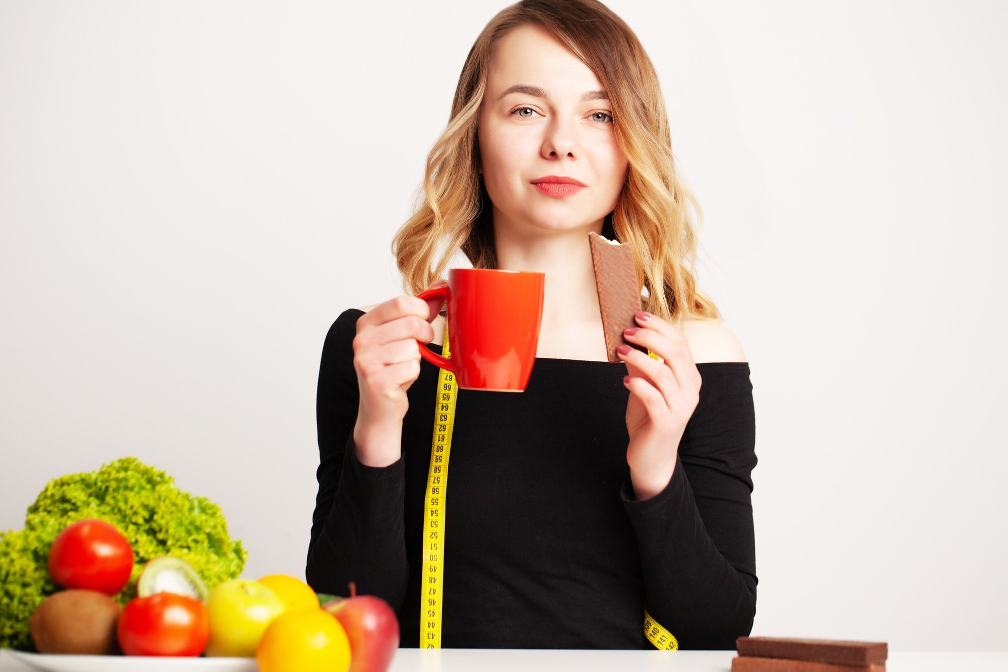 Healthy food, woman at the table with fresh vegetables and fruits eating right for weight loss