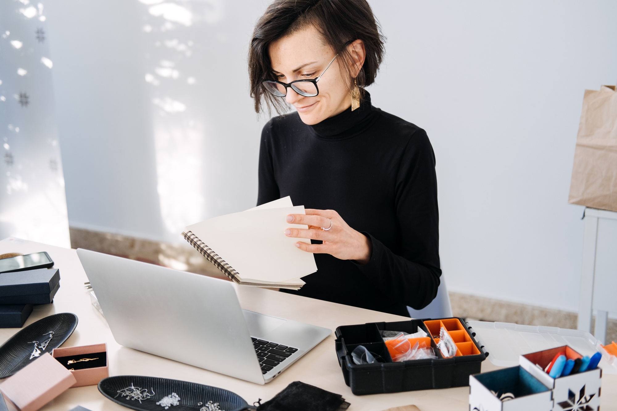 Home-based jewelry business owner planning and managing her brand. Creative workspace, remote