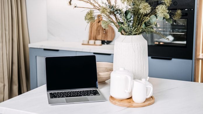 Home Office Setup with Laptop and Cozy Kitchen Decor. A chic home office setup featuring an open