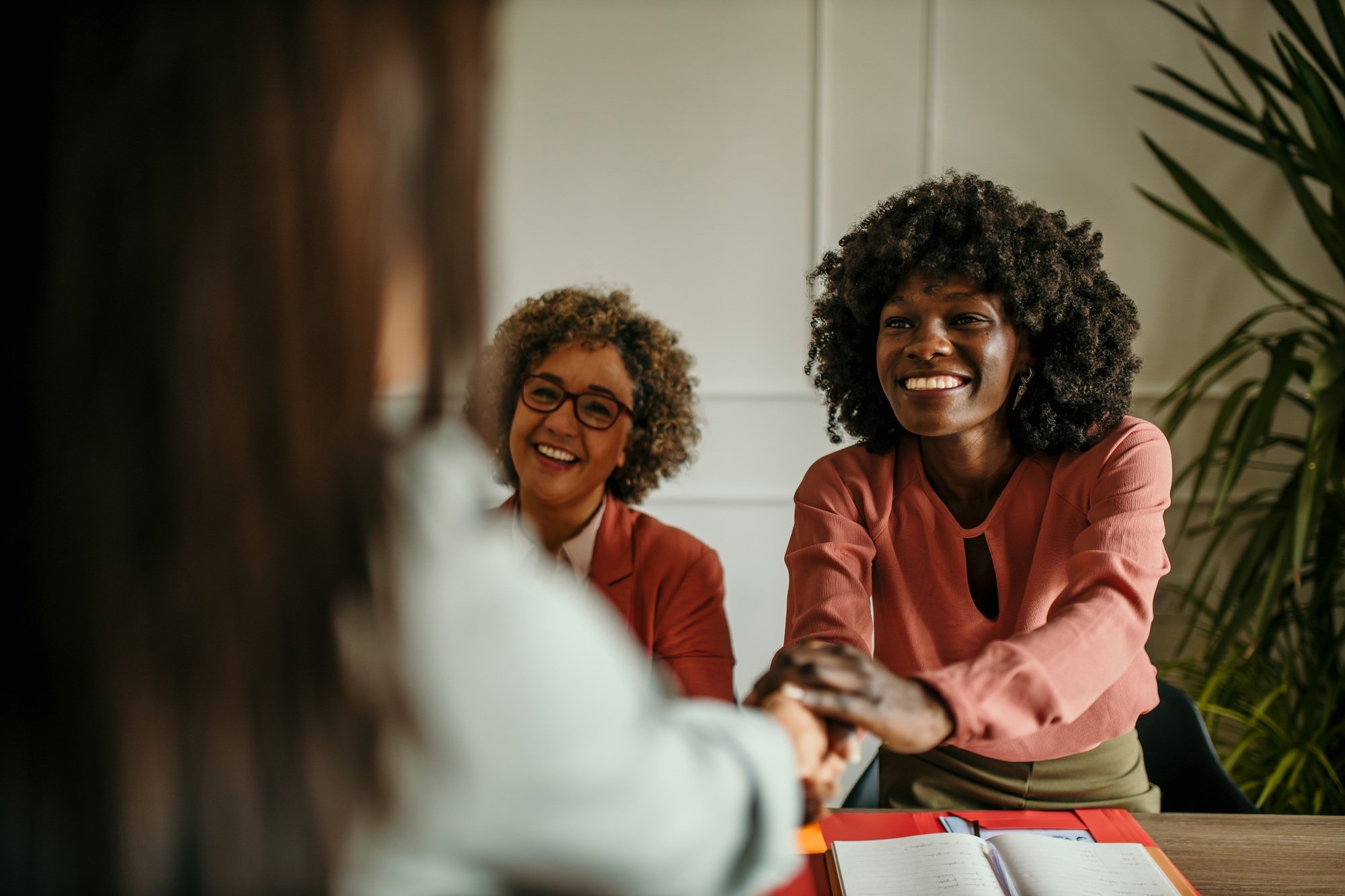 Human resources managers shaking hands with candidate during job interview