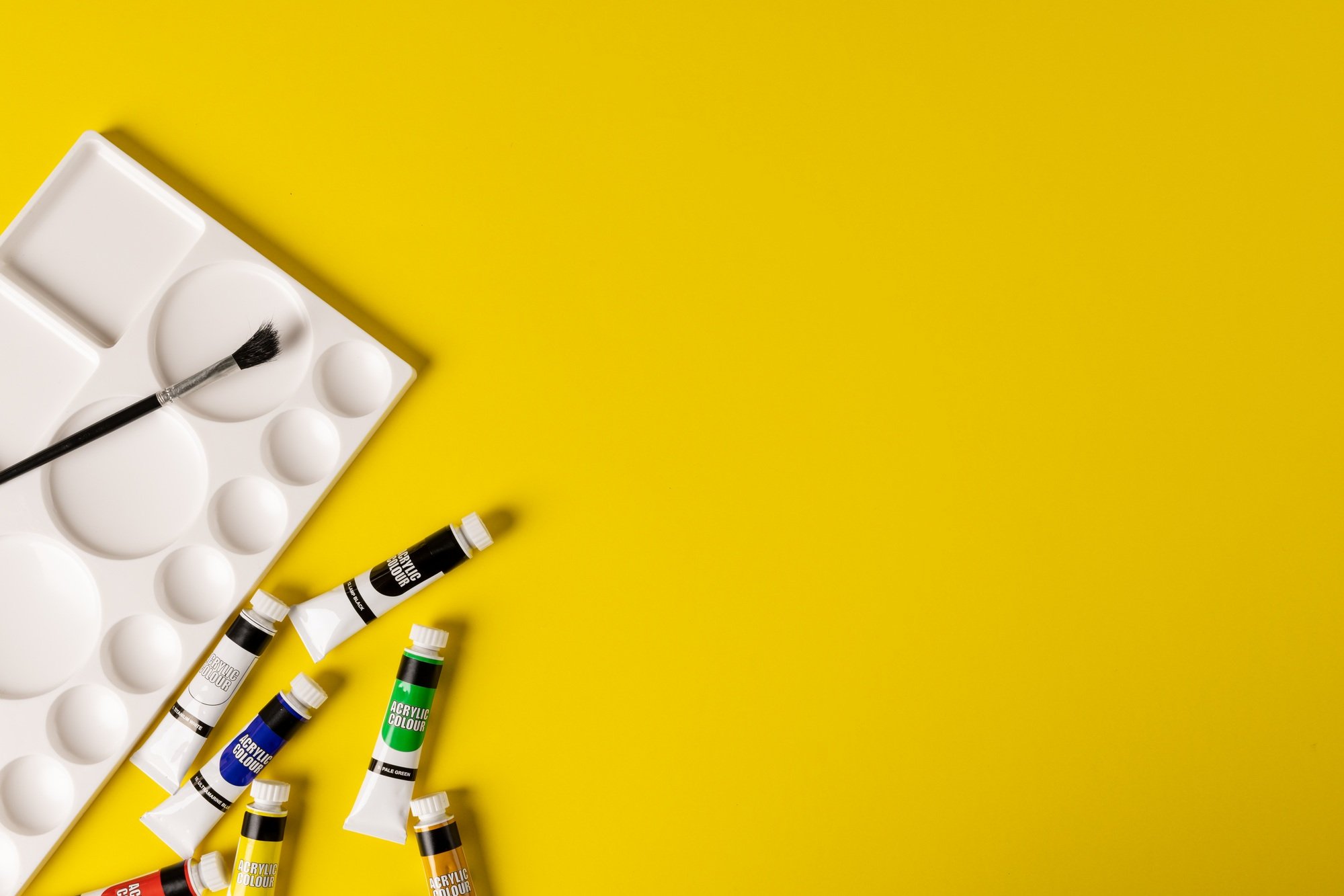 Image of painting tools on yellow surface with copy space