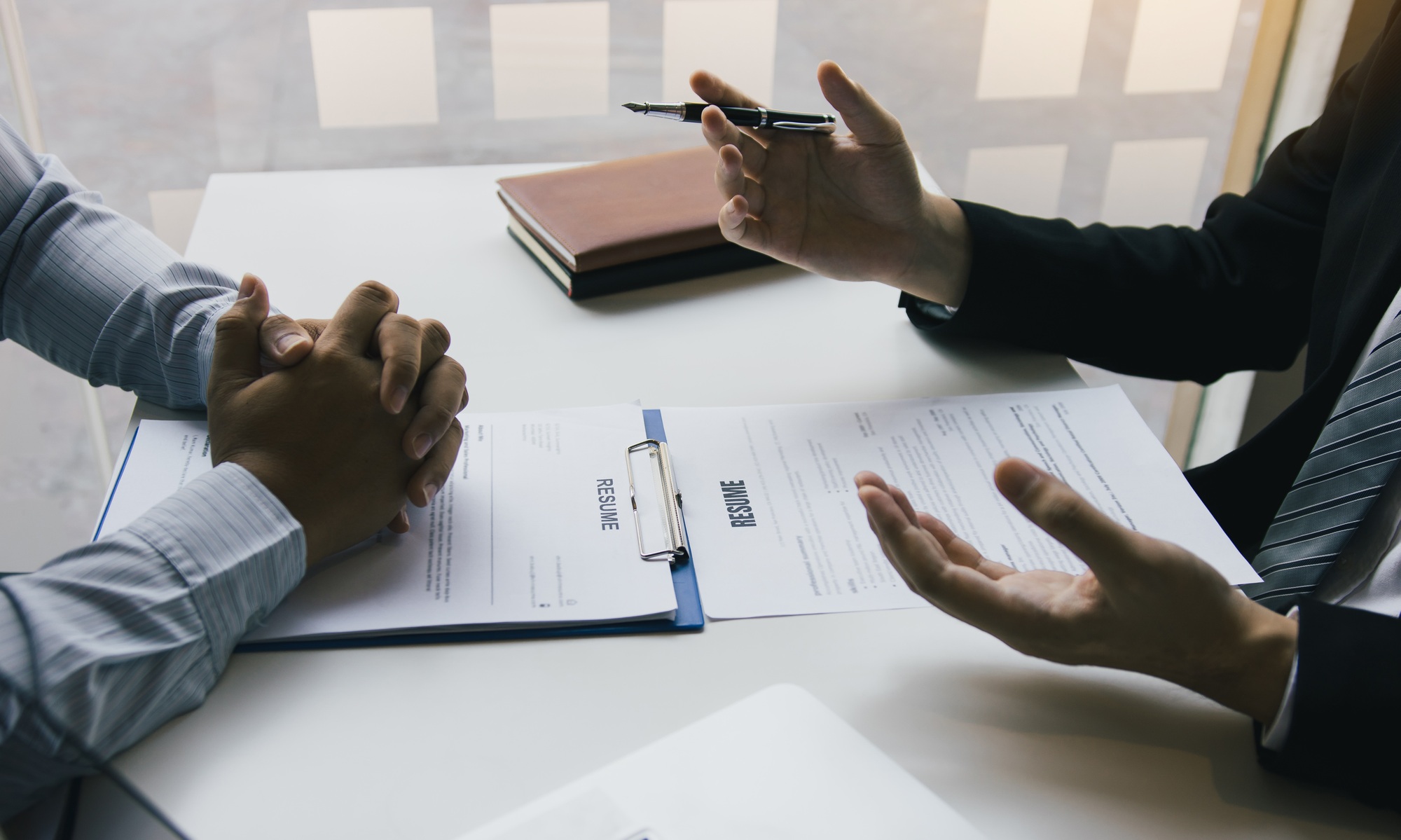 Job applicants are holding a resume document in the job interview room, job interview concept.