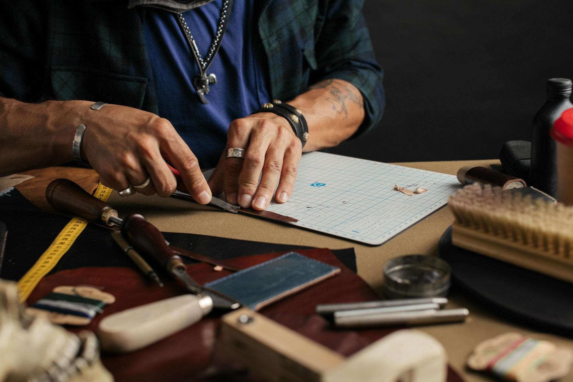 Leather goods master and handmade leather wallets. Workflow in the workshop.