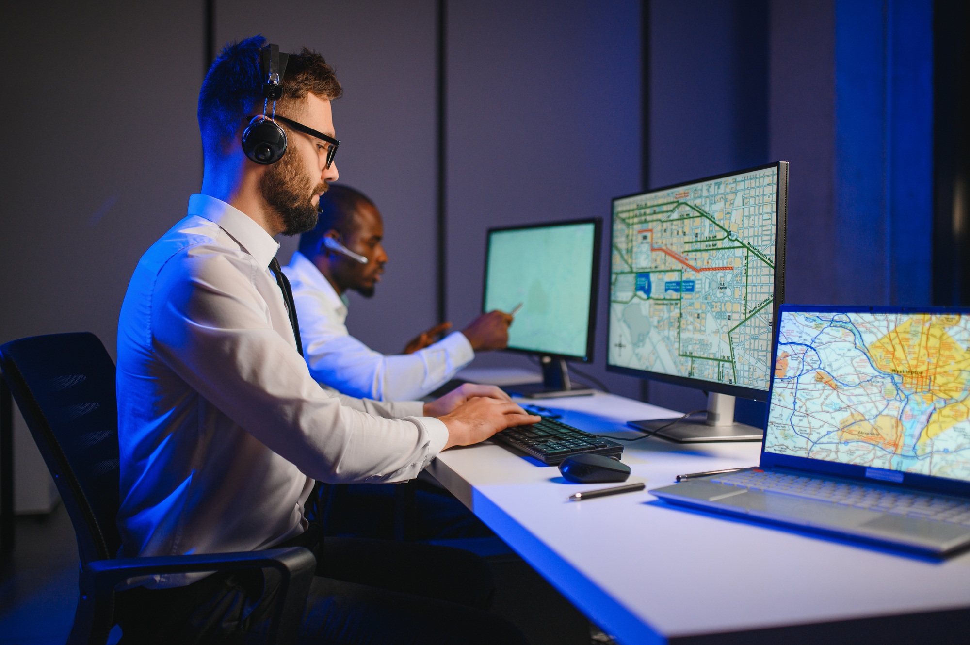 Male Data Scientist Works on Personal Computer Wearing a Headset