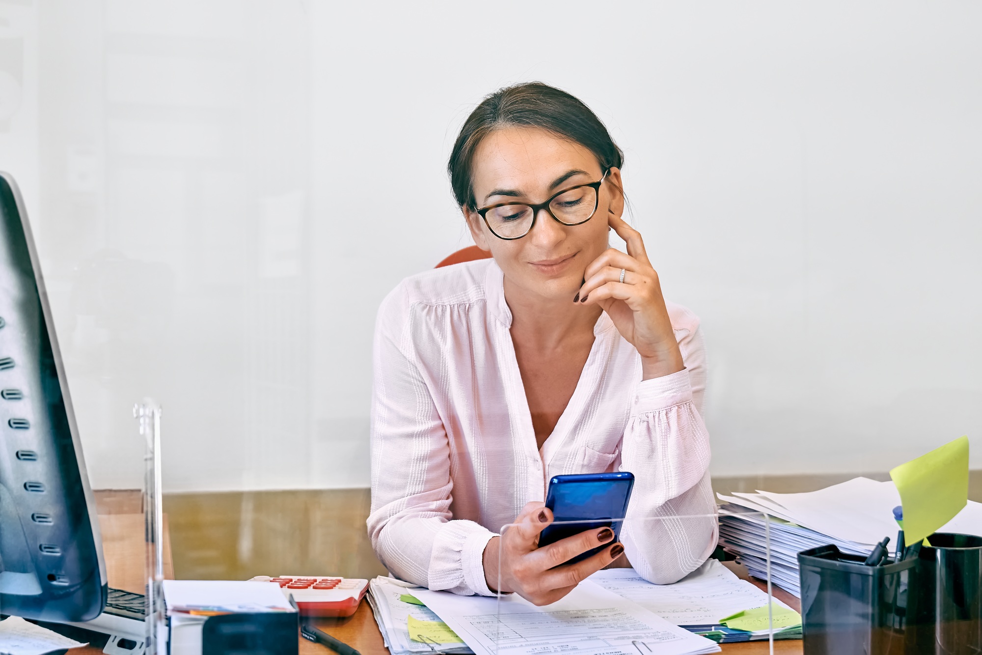 Middle-aged businesswoman checking email messages on mobile phone