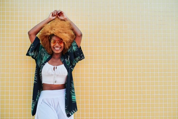 Modern afro woman smiling while posing with summer clothes