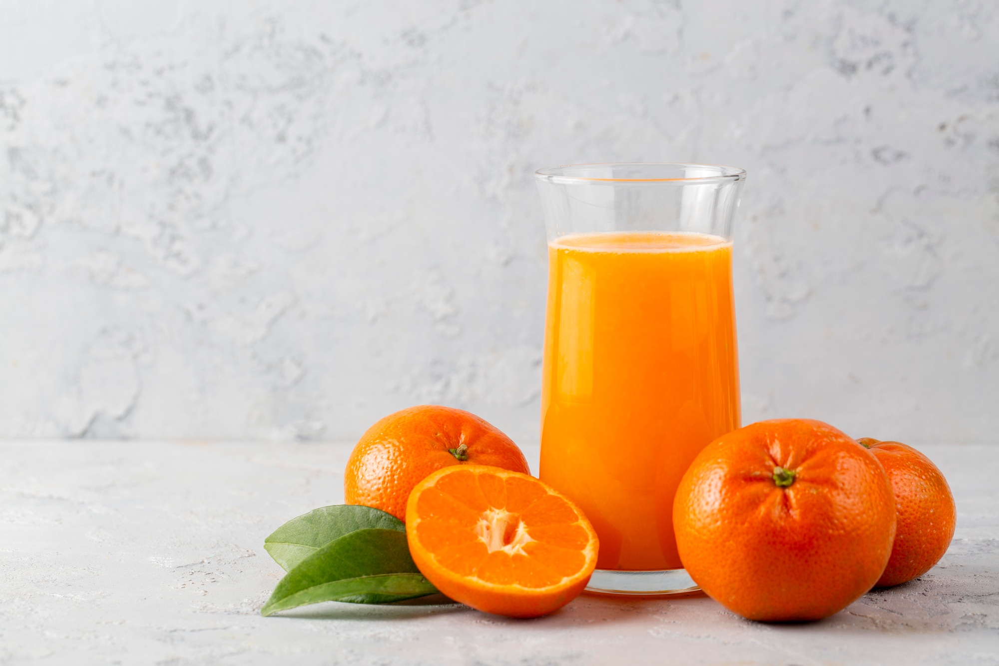 Orange tangerine fruits and glass of fresh tangerine juice