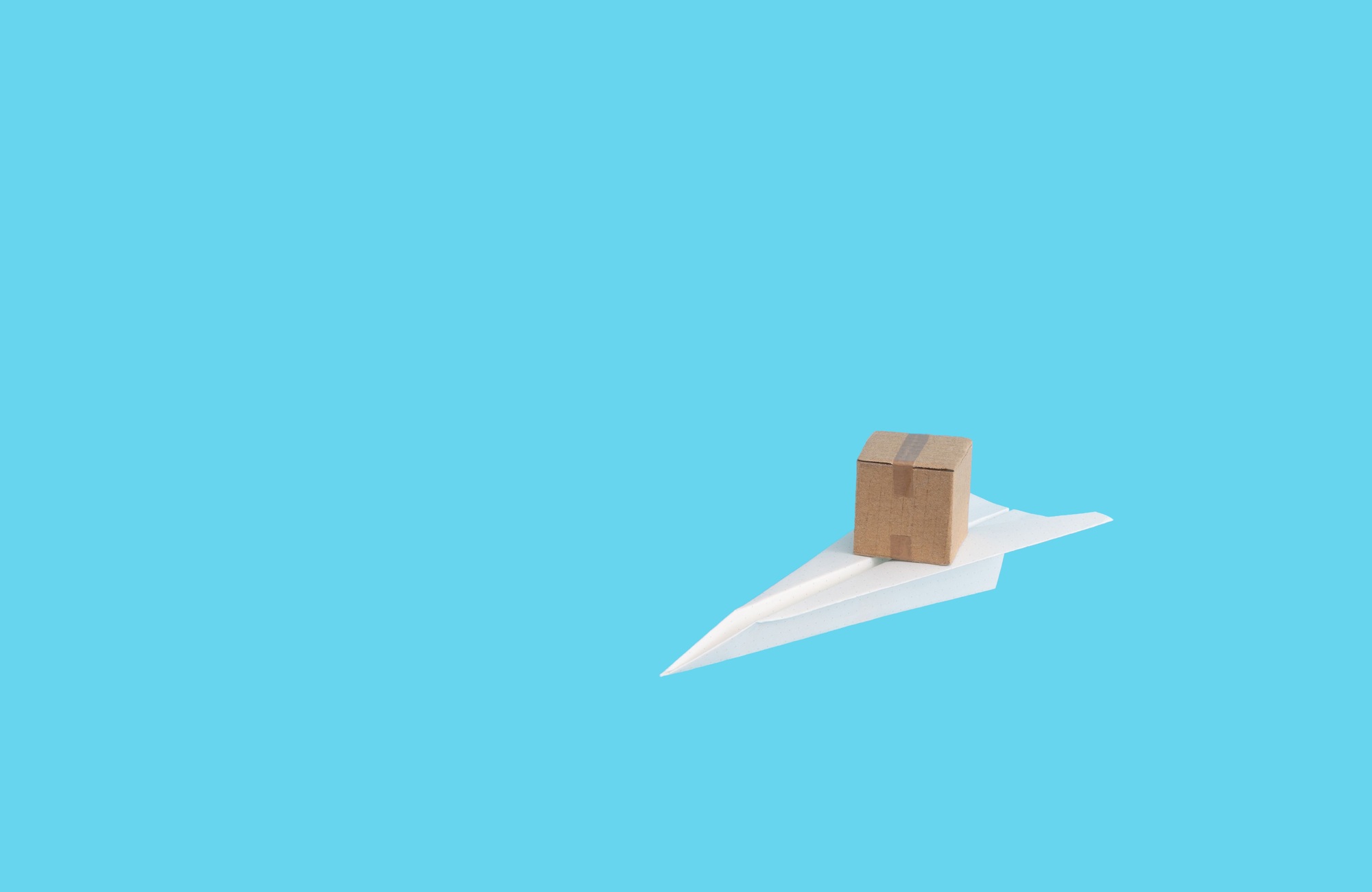Paper plane with a cardboard package on it, shipping and delivery service concept