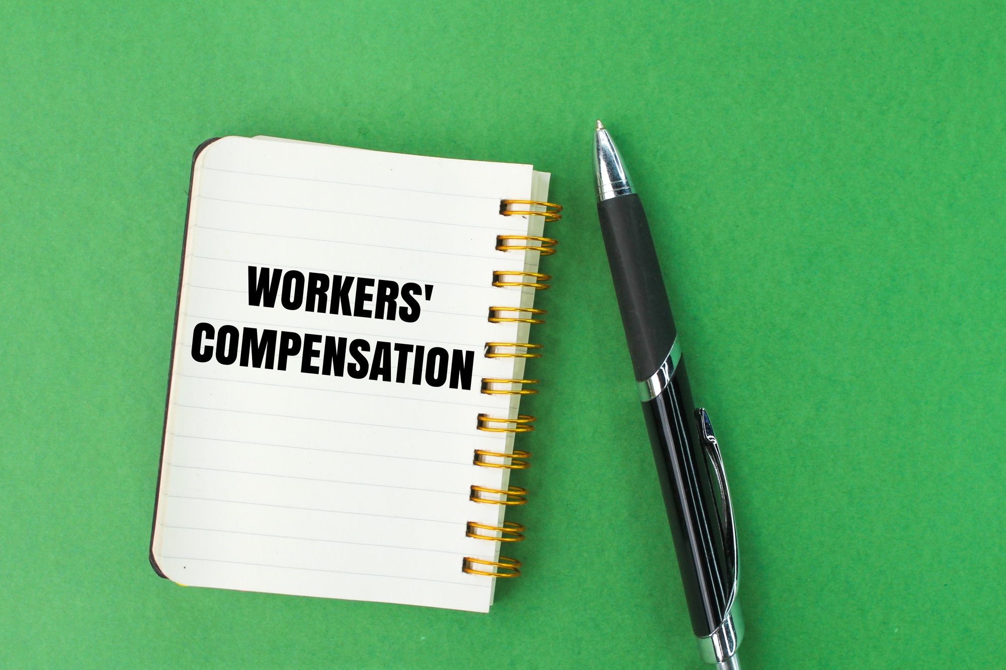 pen and notebook with the words workers' compensation