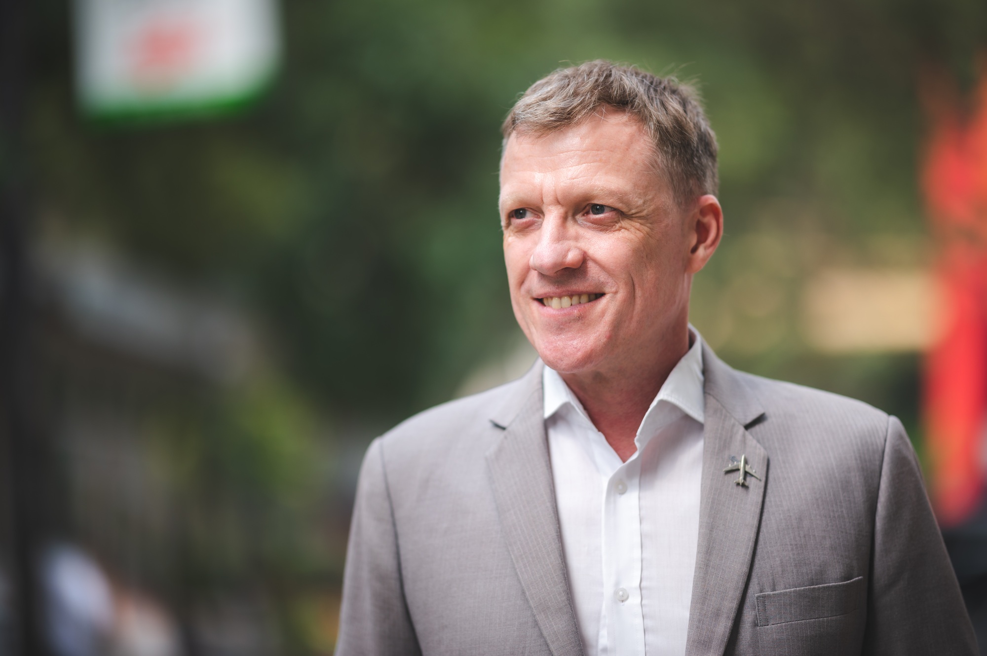 Portrait of handsome mature business man in formal clothing with side bag riding a cycle