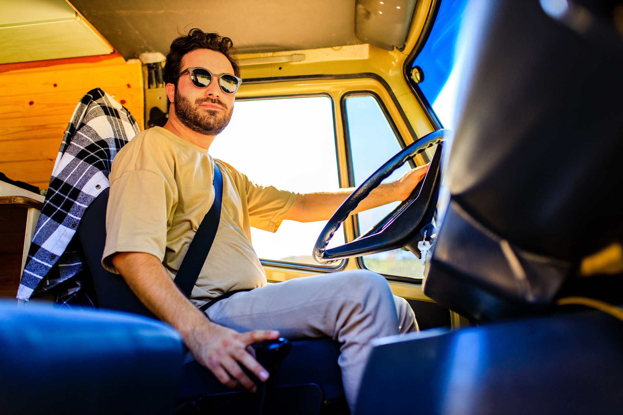 Portrait of young bearded trucker in his truck vehicle house
