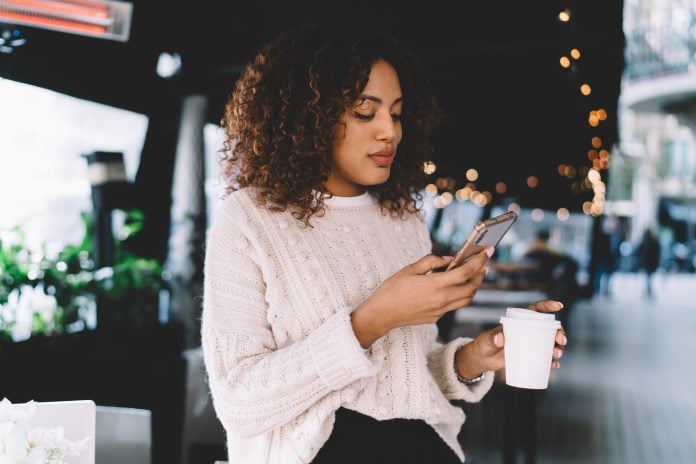 positive african american woman influencer share multimedia content on cellphone