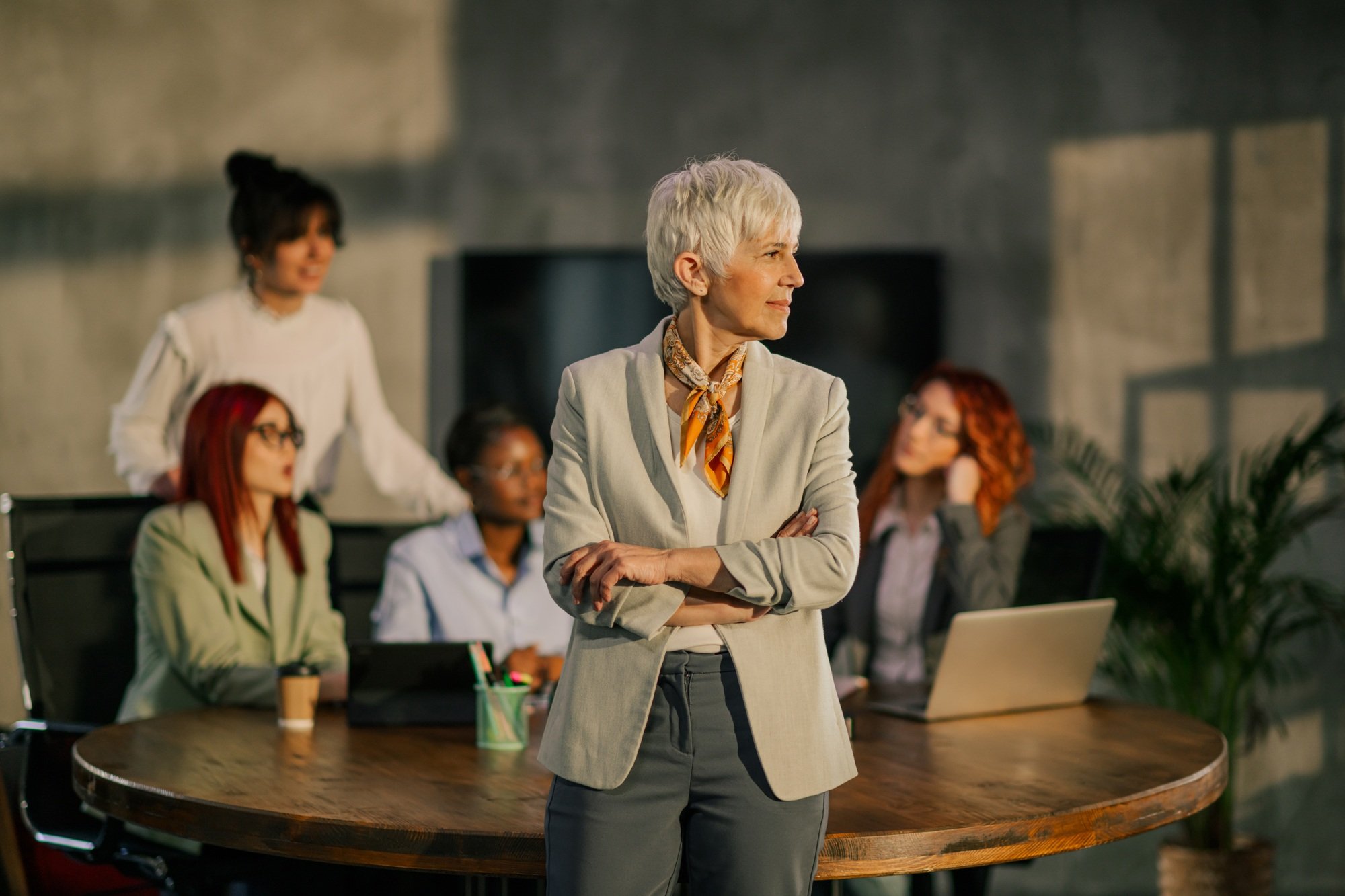 Profile view of mature businesswoman standing at meeting room.