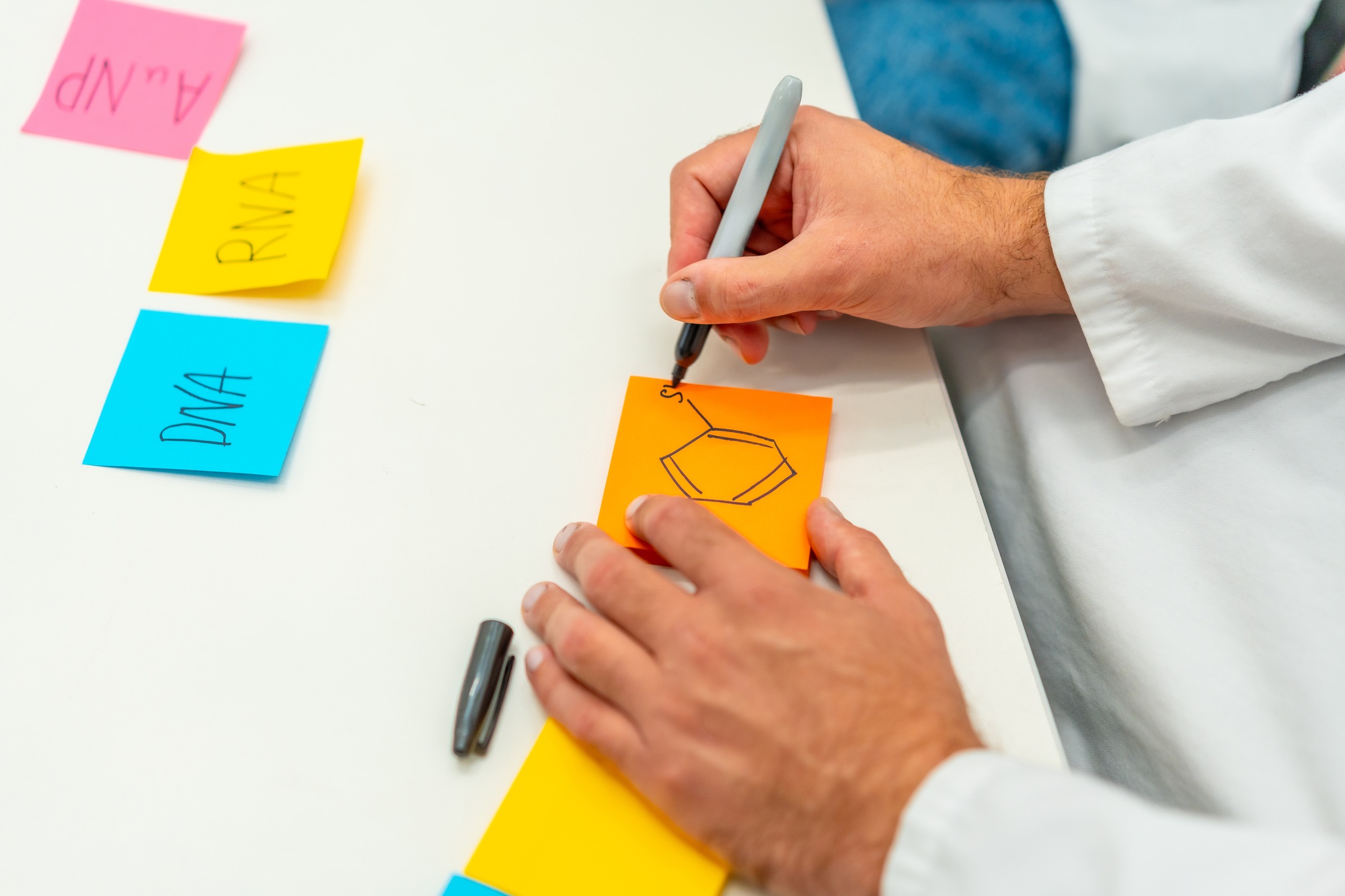Scientist writing notes during a brainstorming process in a lab