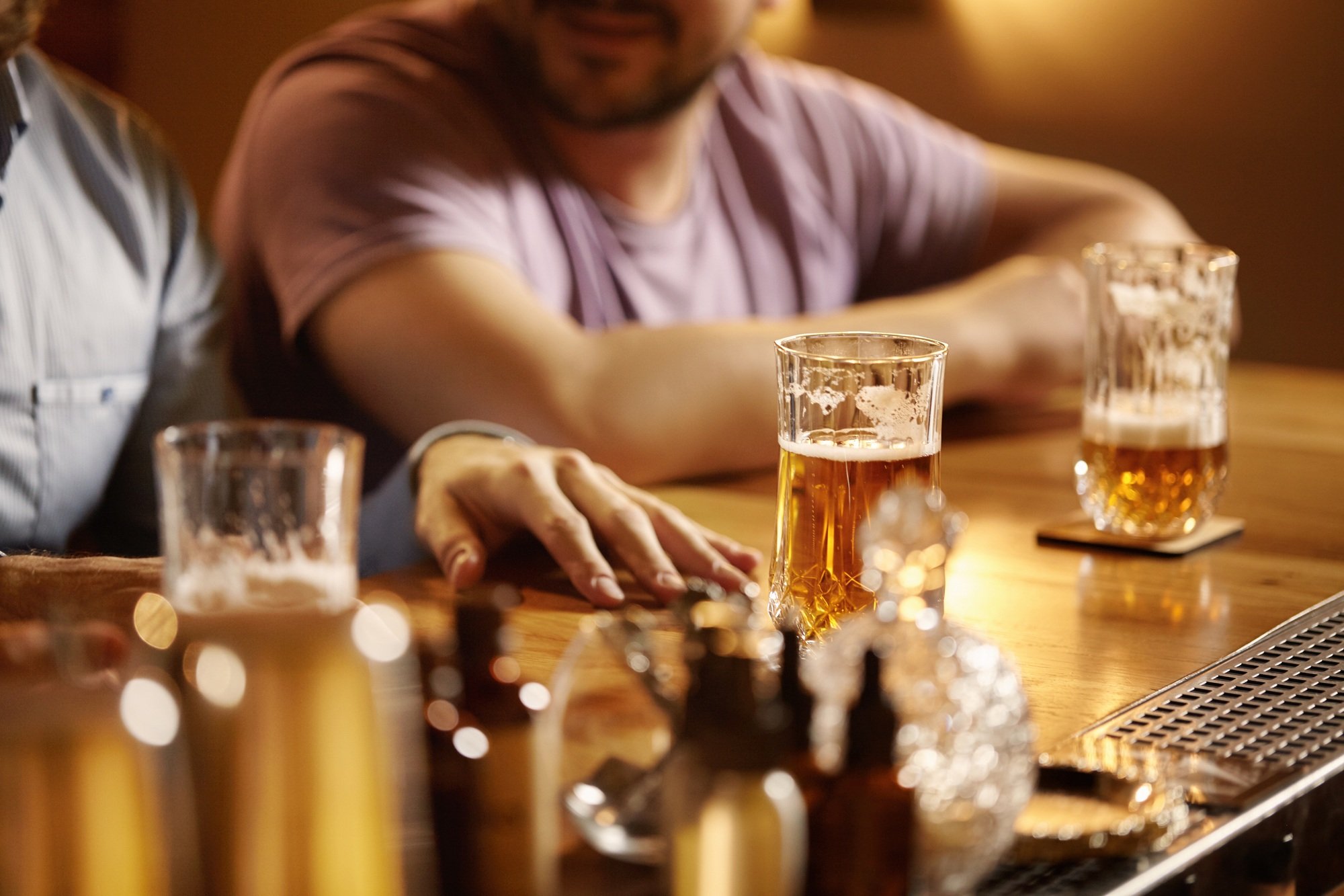 Selective focus. Old friends meeting at pub over beer. Two partners having good time at bar, celebra