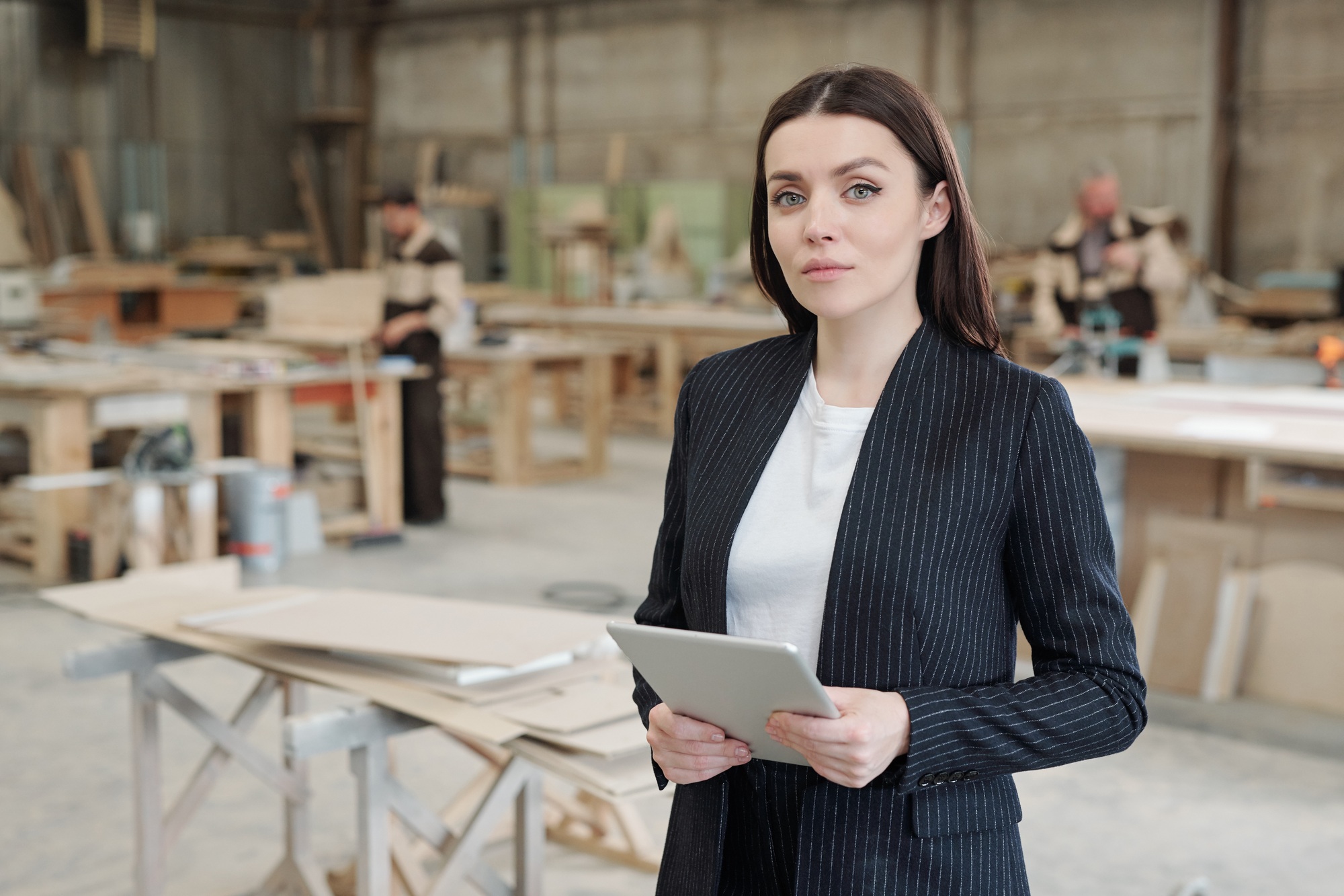 Serious sales manager of furniture factory using touchpad in front of camera
