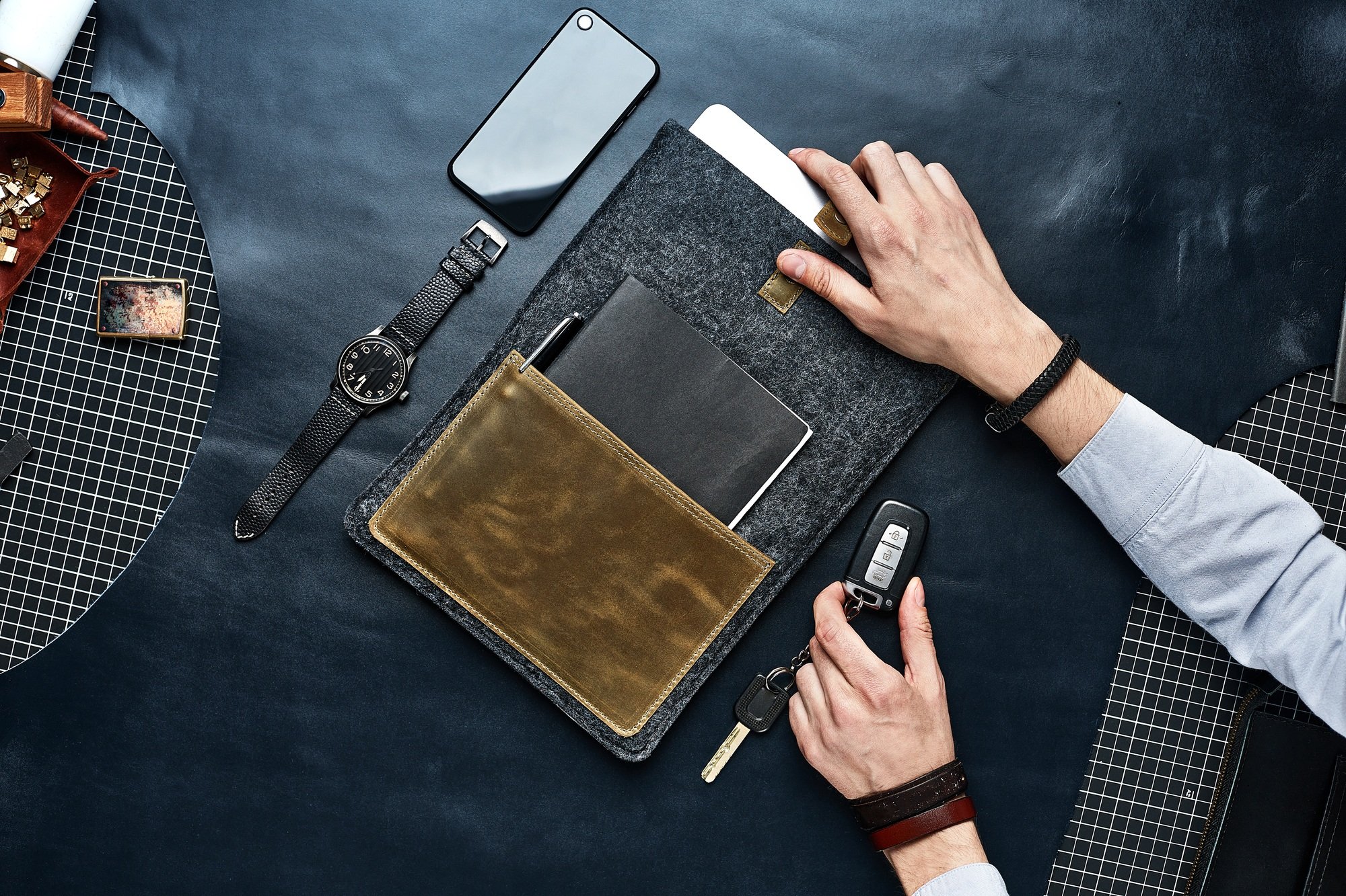 Set of handmade leather goods in male hands, key holder rings, wallet, purse, notepad, handbook