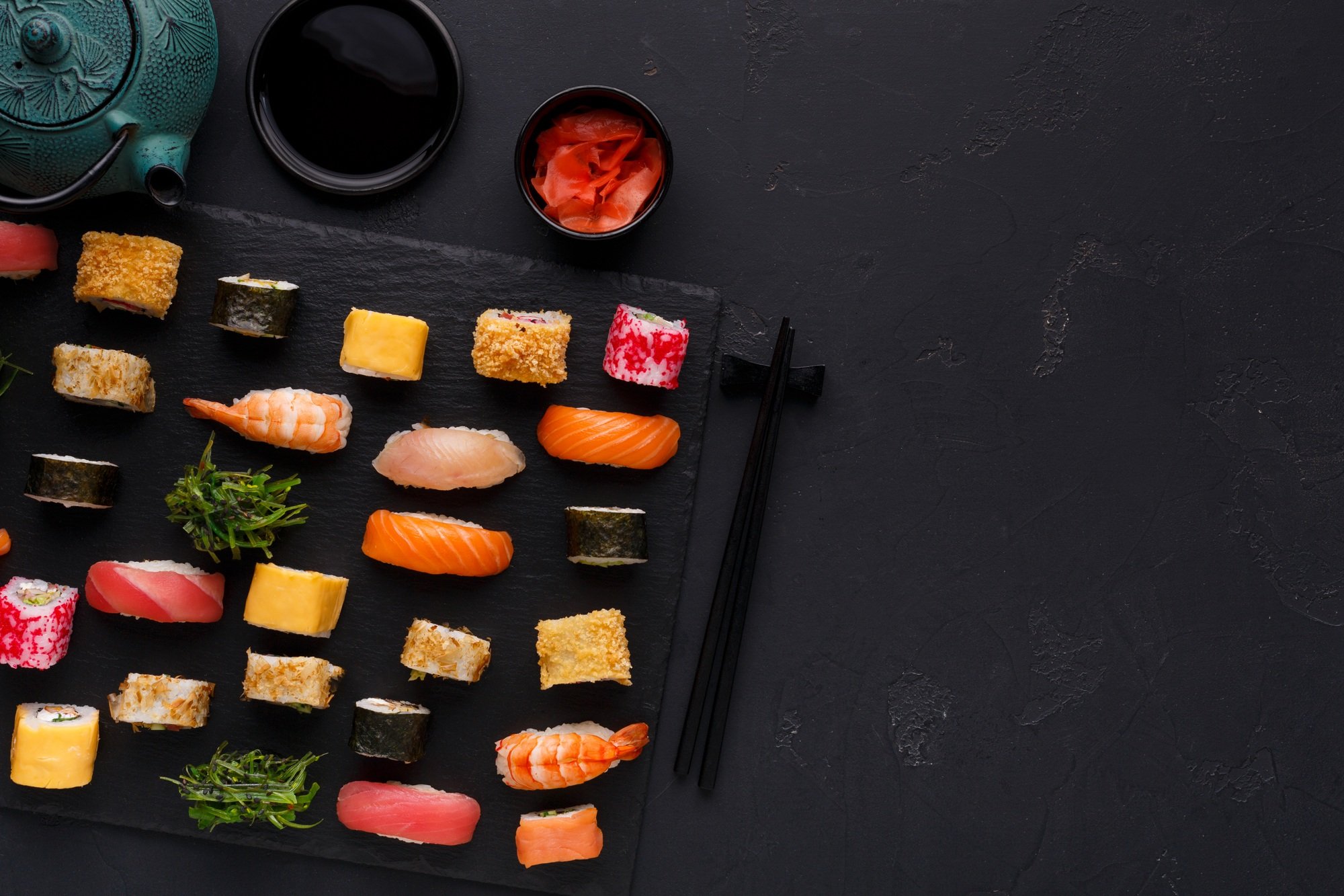 Set of sushi maki and rolls on black background