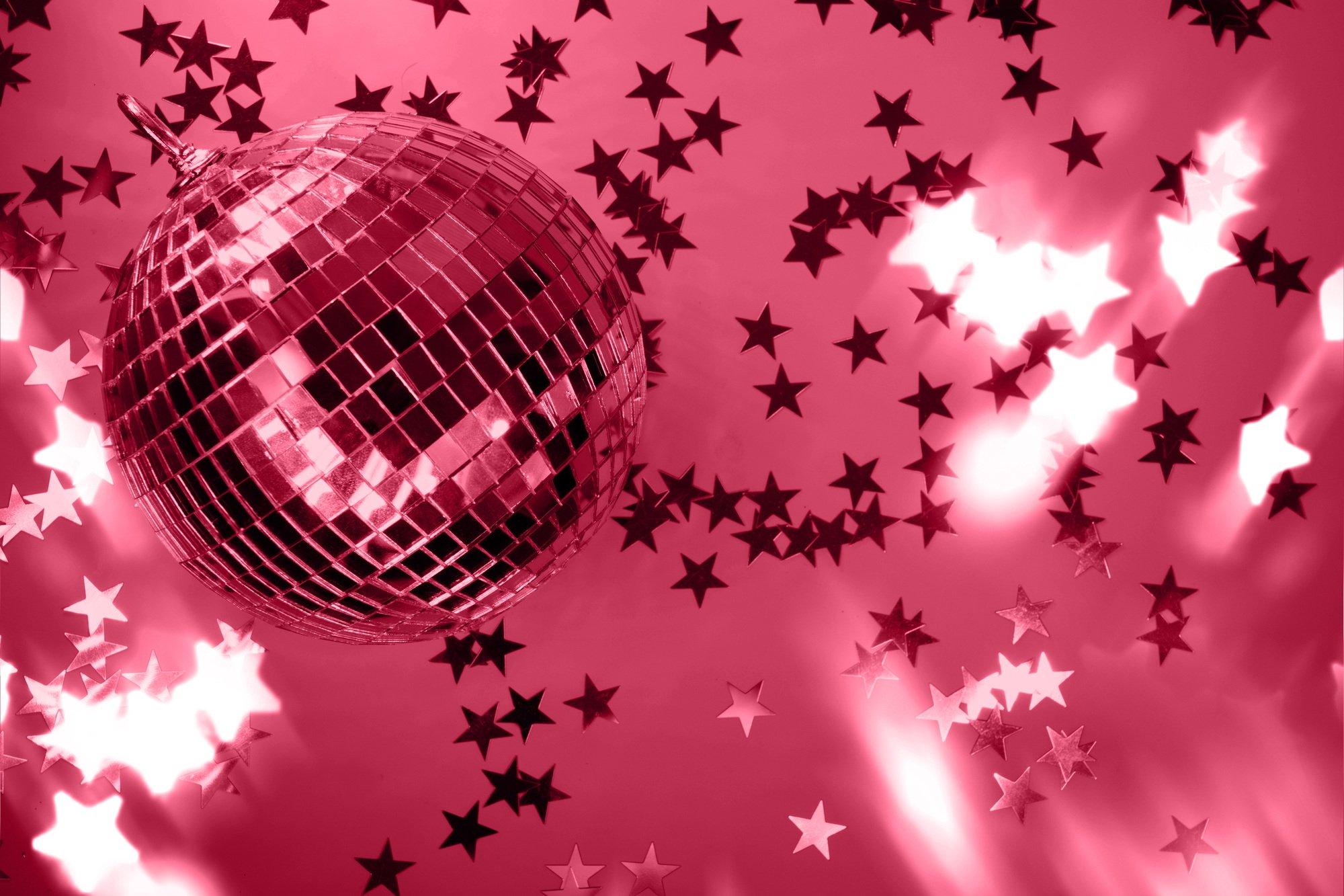 Shiny disco ball with rays on viva magenta background. Trending color of 2023.