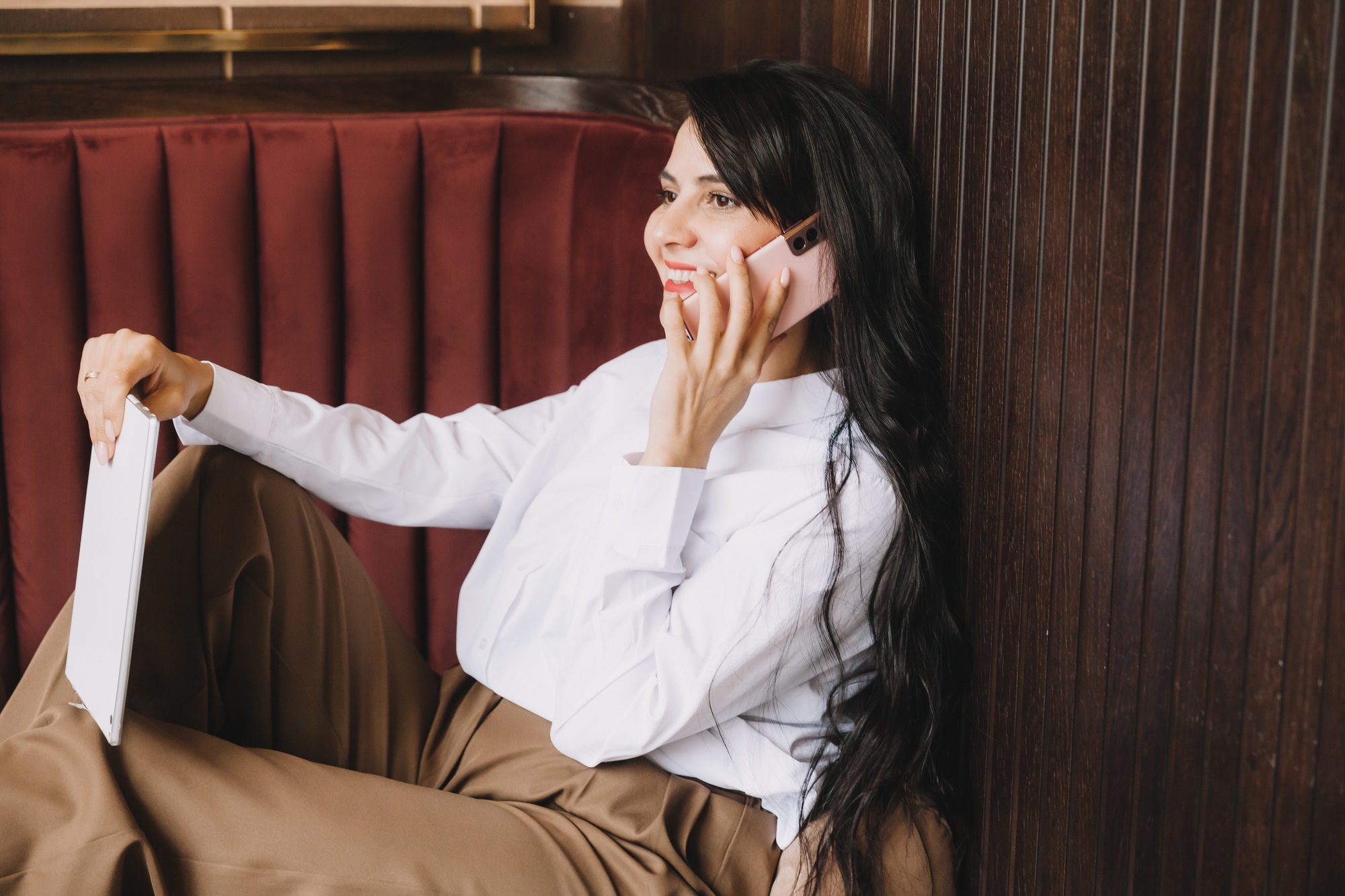 Side profile photo of a business woman talking on the phone. businesswoman sitting on a sofa