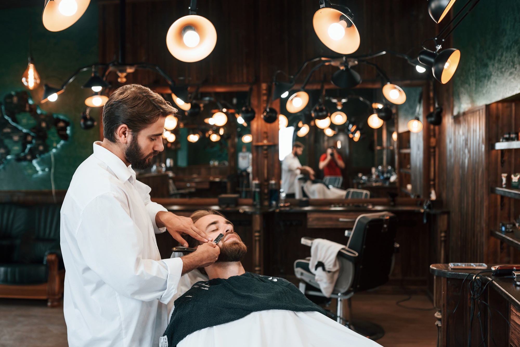 Sitting on the chair. Man is visiting modern barber shop. Modern style