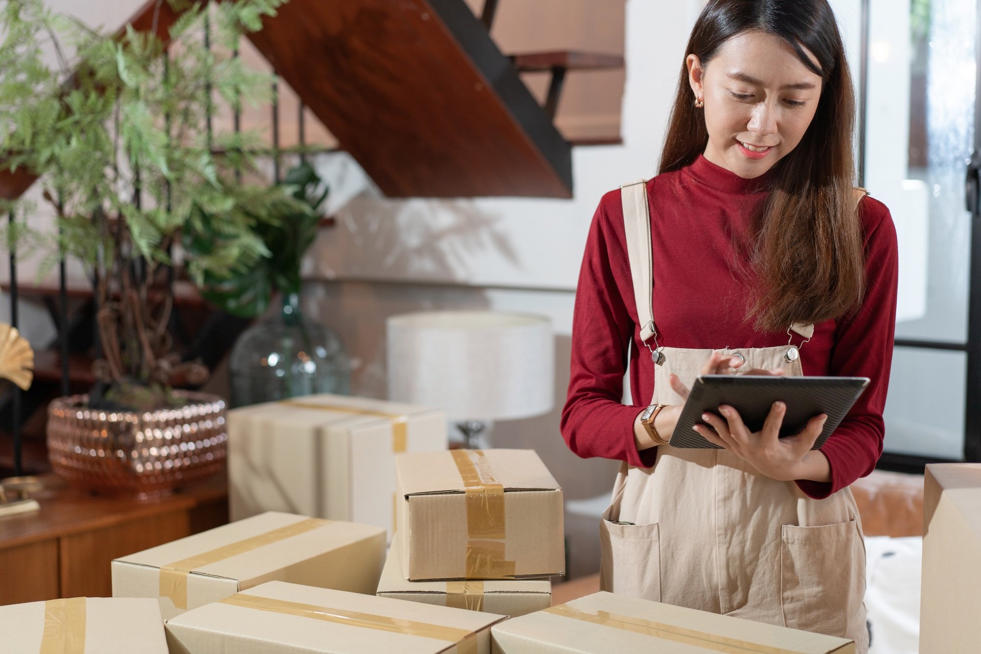 Small business female shop owner checking customer order on digital tablet