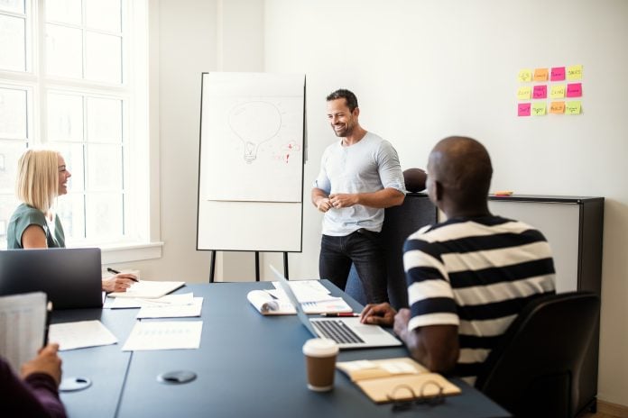Smiling manager talking with staff during an office presentation