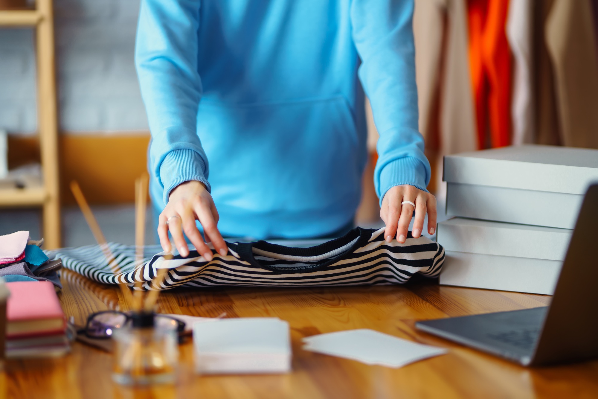 Smiling woman takes notes of orders from with laptop. Dropshipping owner works.