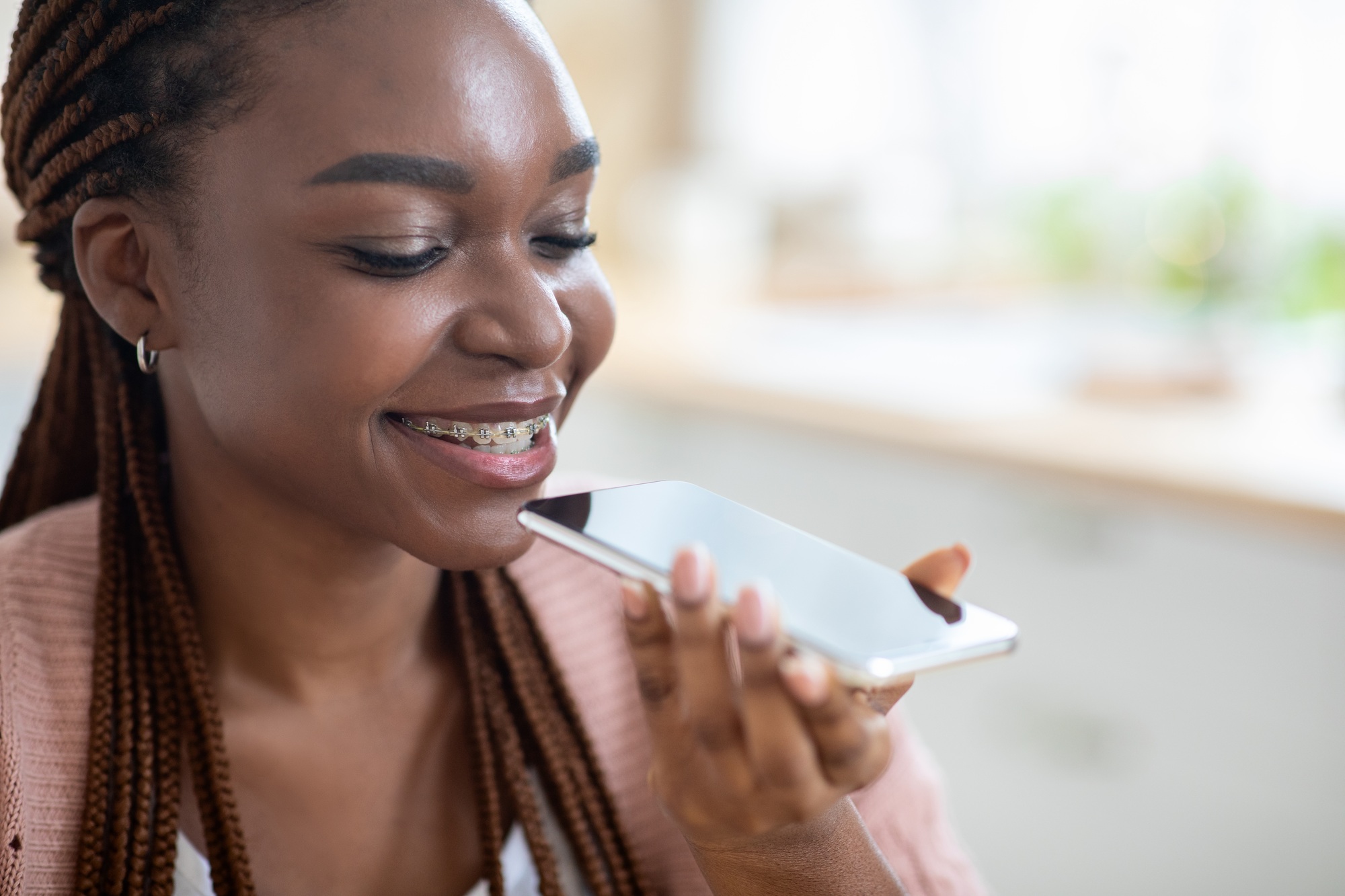 Smiling Young Black Female Using Virtual Voice Assistant Option On Smartphone
