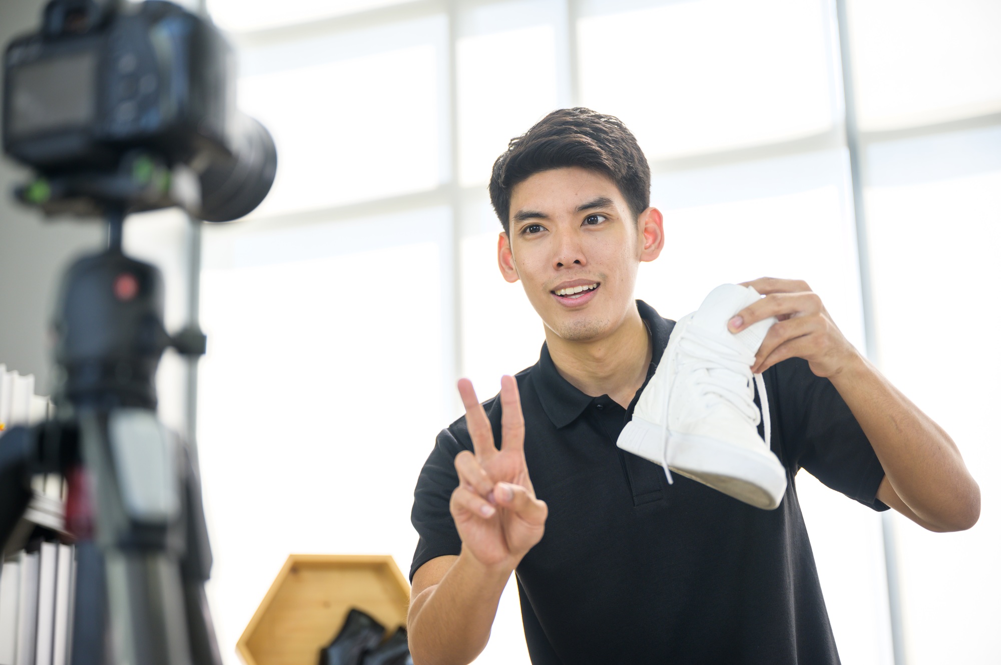 Social media influencer reviewing fashion shoe. Smiling young man vlogging