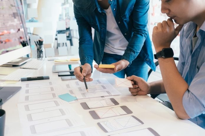 Software developer and UX UI designer are designing mobile application.