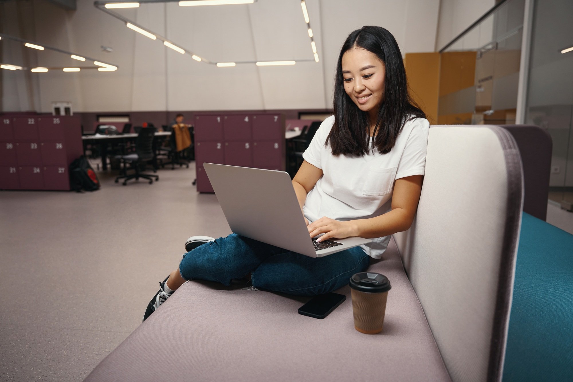 Stylish Asian female manager is responding to the email in workspace