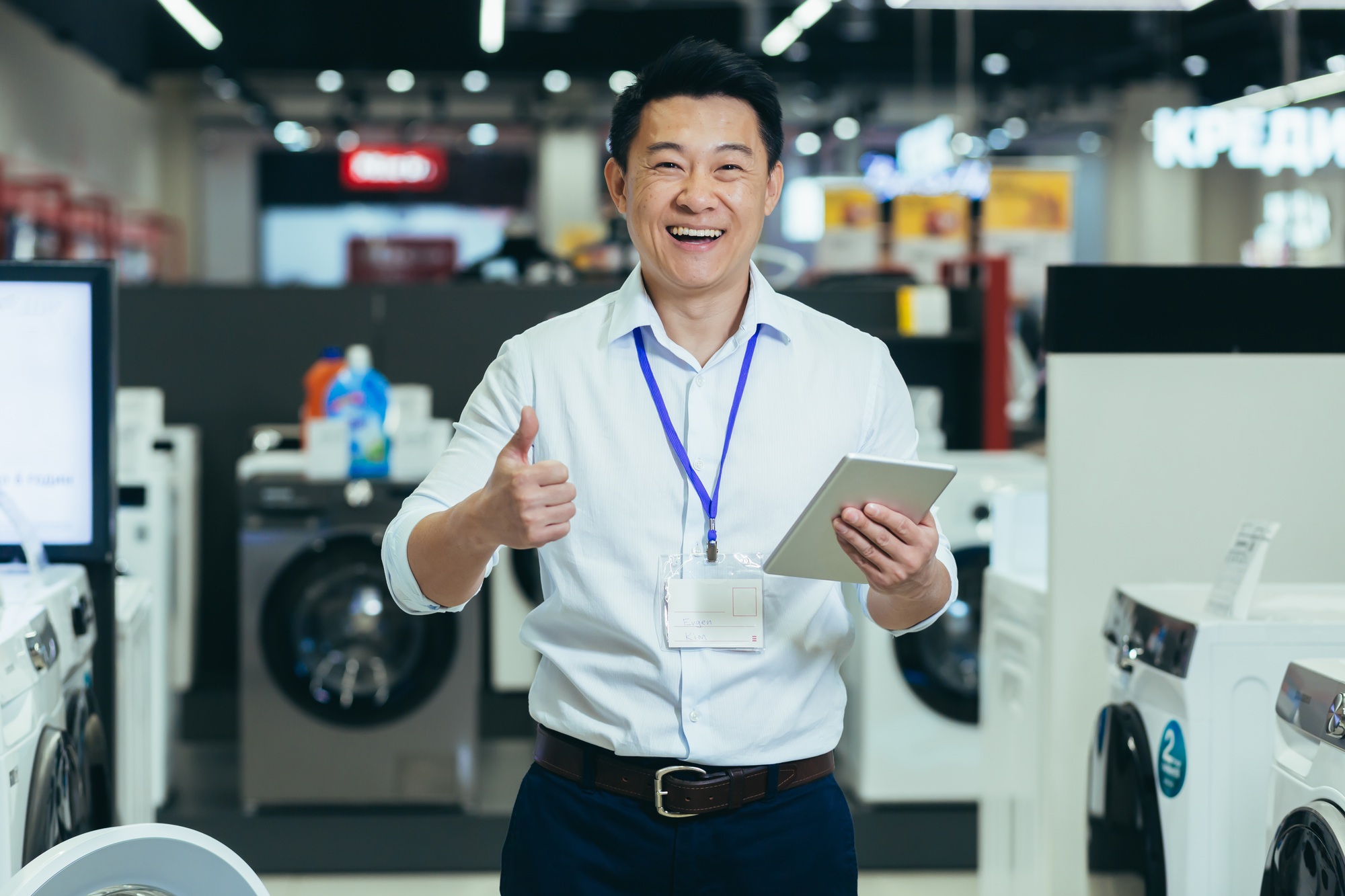 Successful sales consultant in electronics supermarket, Asian man working appliances store smiling