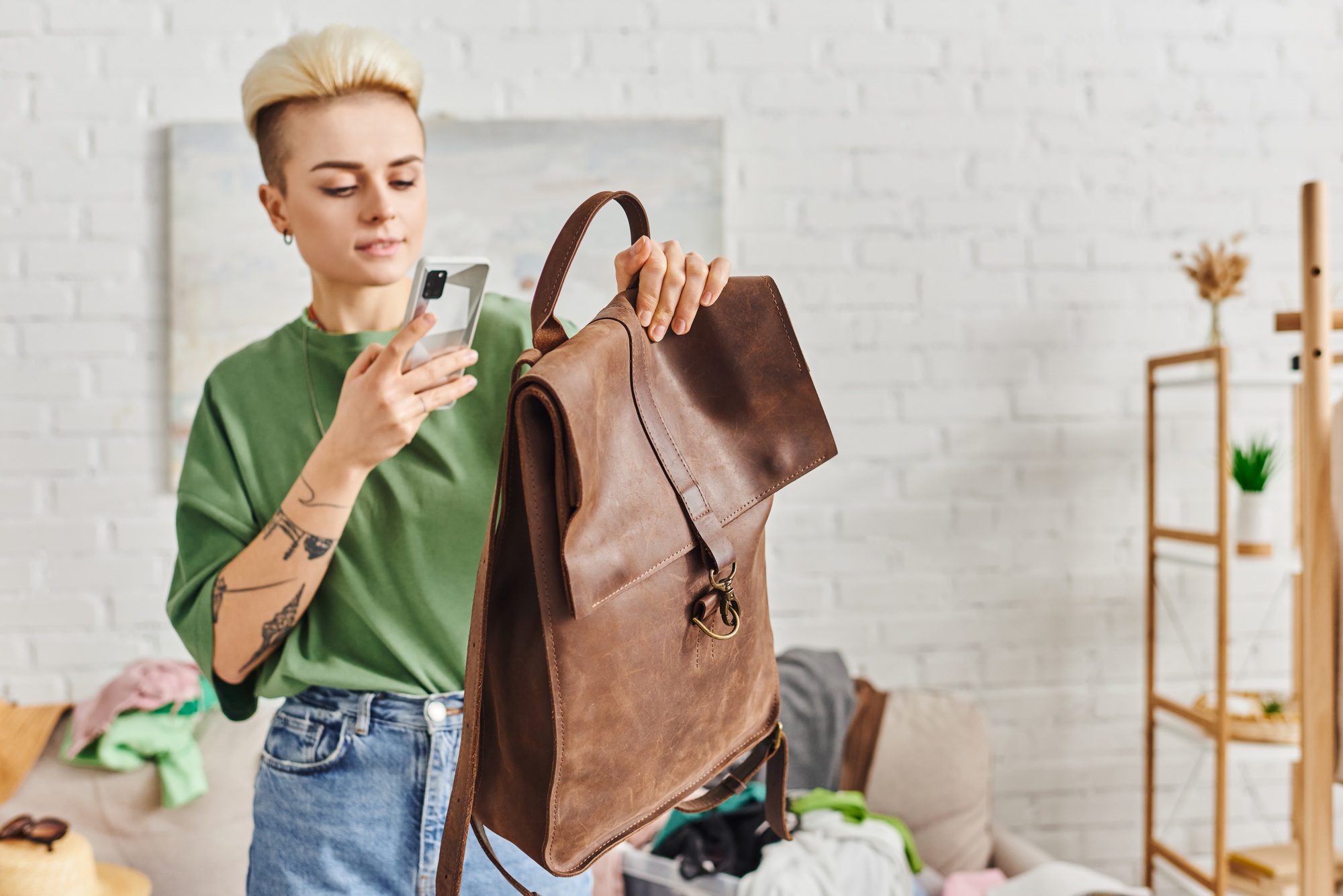 swap on virtual marketplace, young woman with tattoo and trendy hairstyle taking photo of leather