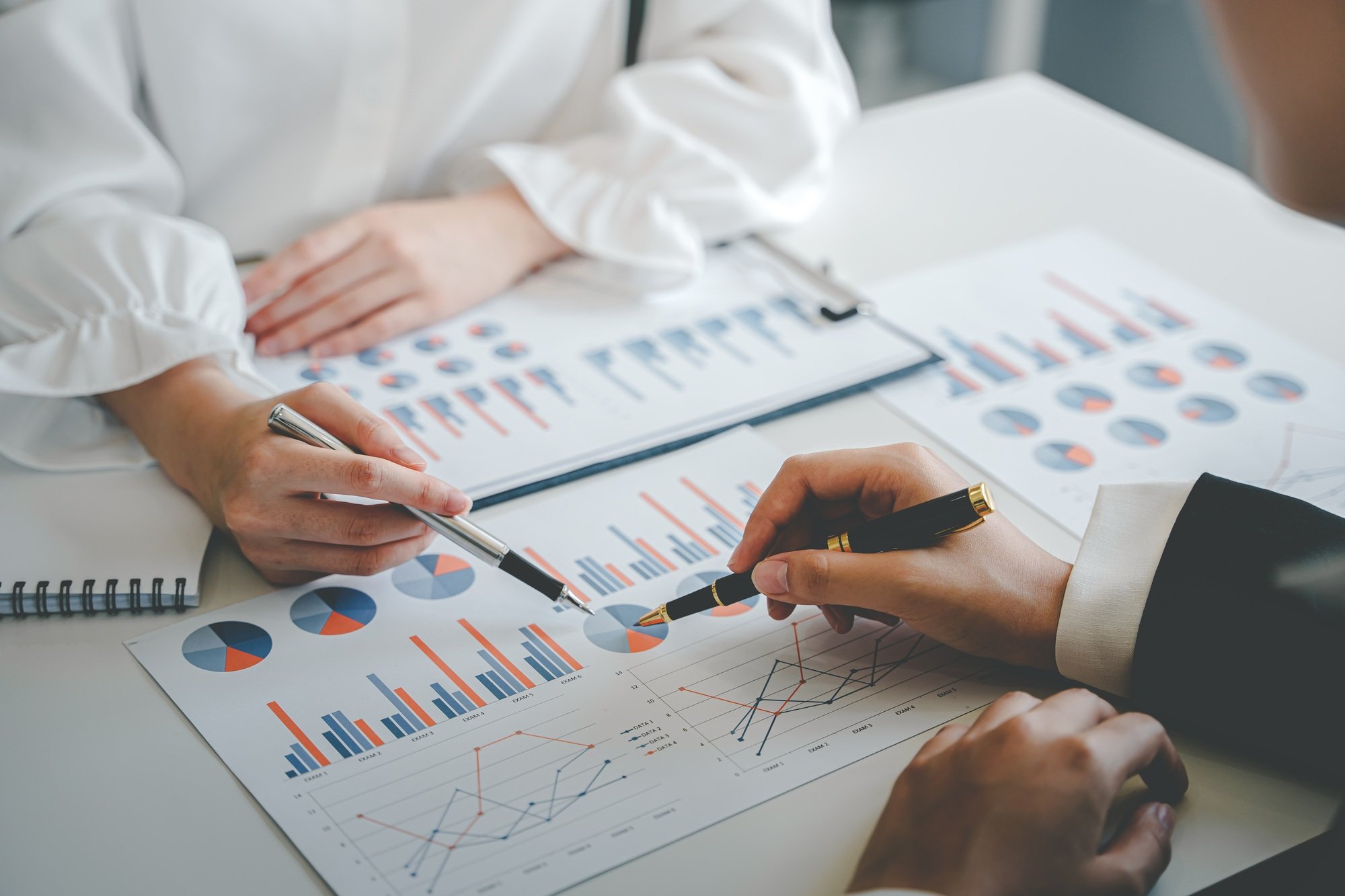 Teamwork with price chart analyzes business people on the table at the conference room.