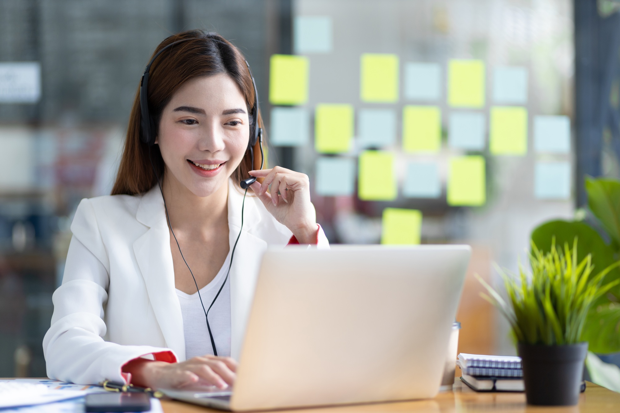 Telephone operator or customer service representative working in a call center office.