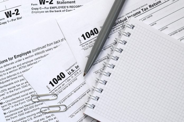 The pen and notebook is lies on the tax form 1040 U