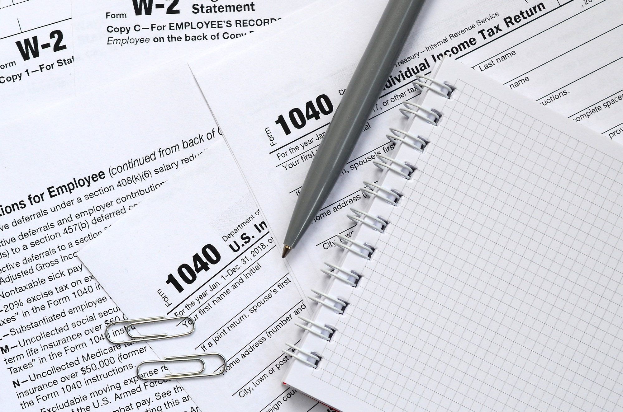 The pen and notebook is lies on the tax form 1040 U