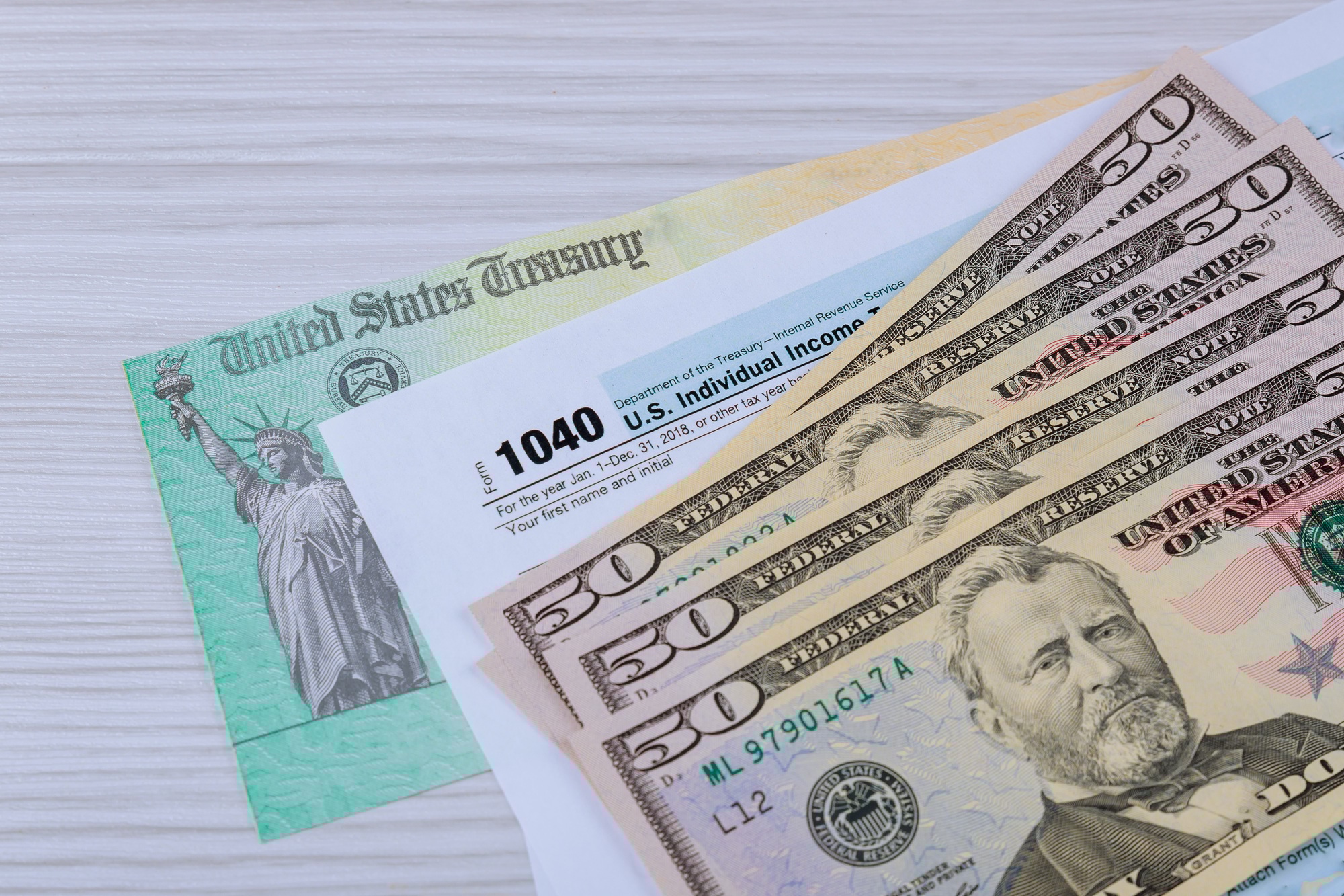The tax forms 1040 with the money and the pen.